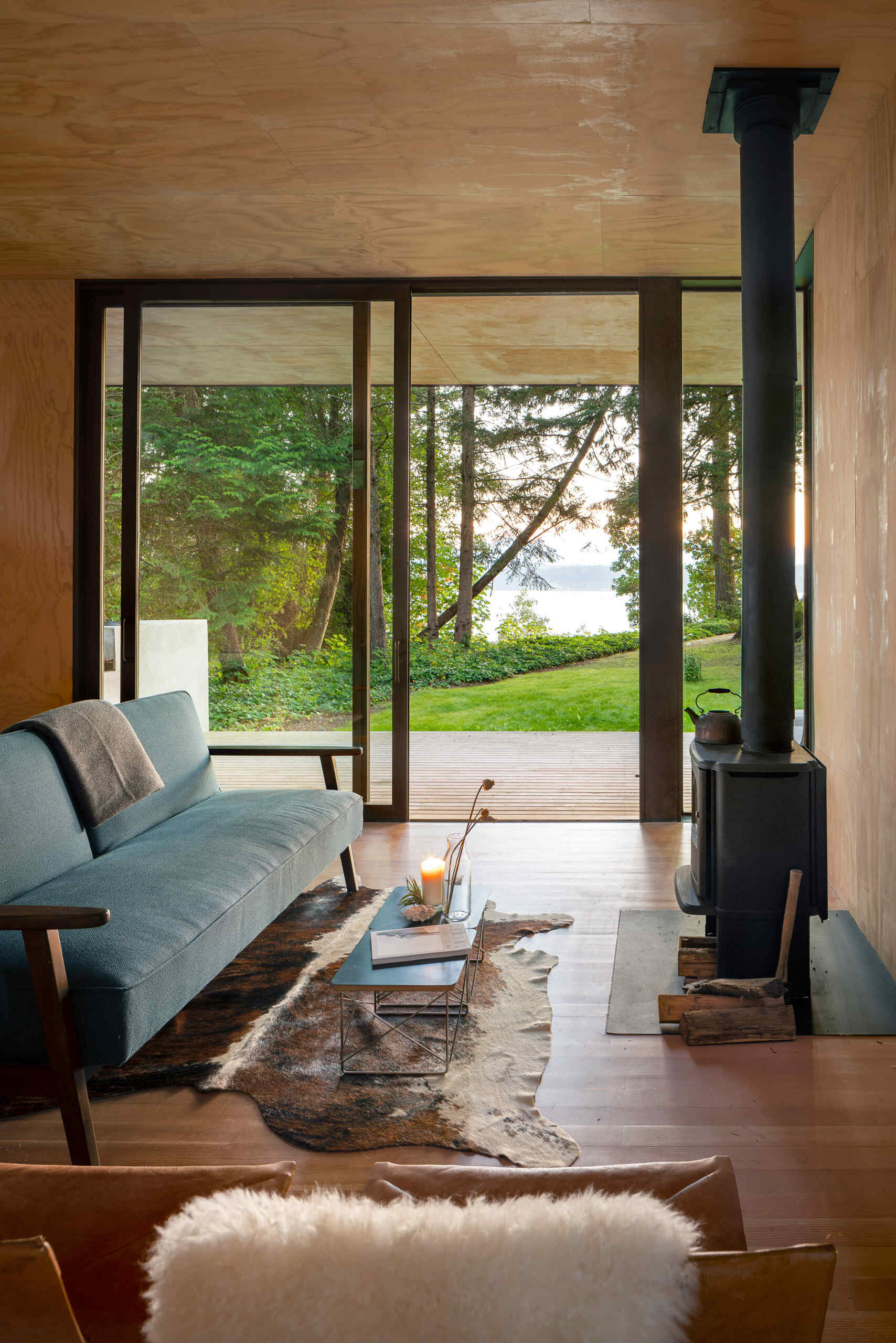 A cabin living room has a sliding glass door that opens to a wood deck.