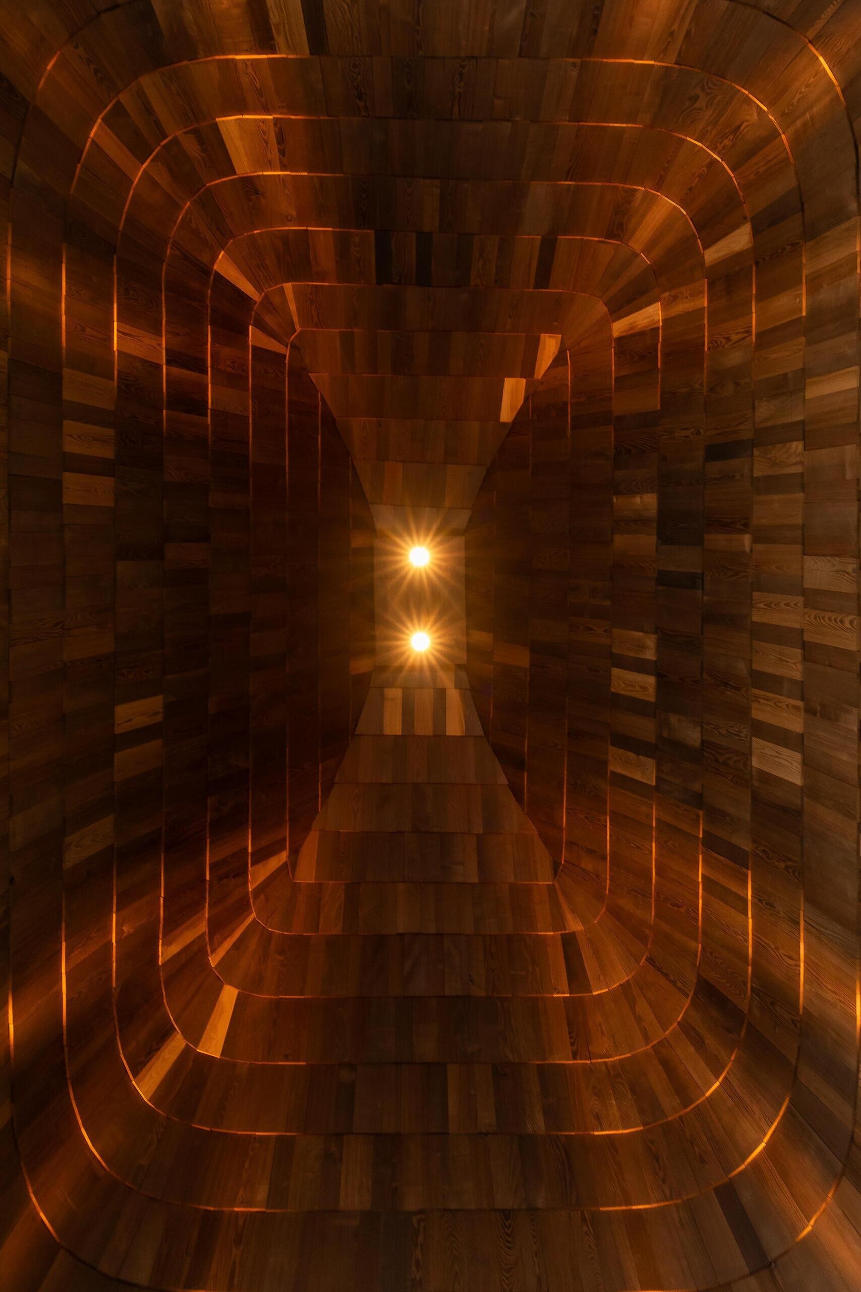 This roof dome rises to ten metres and is lined with wooden shingles, concealing all engineering systems and keeping the interior visually clean.