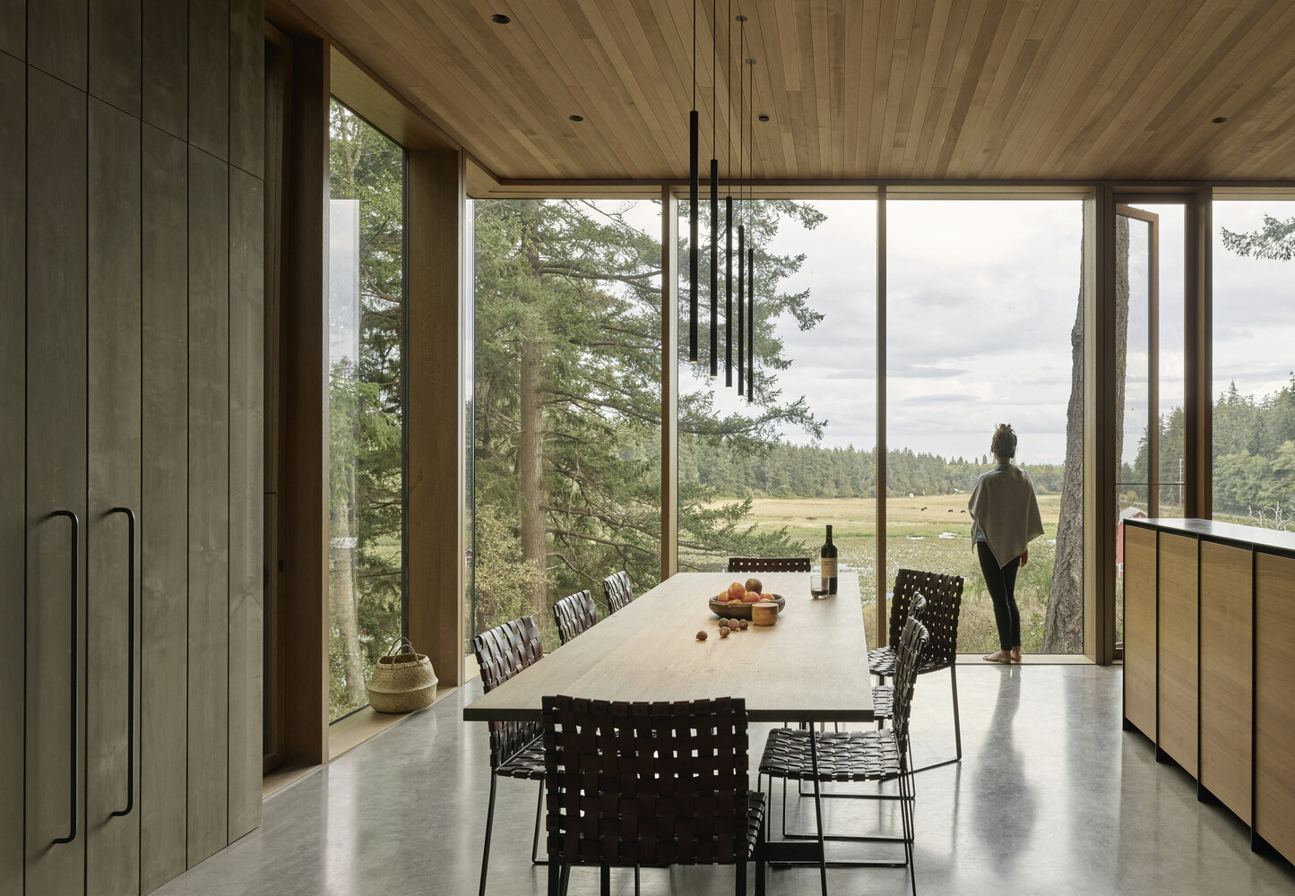 This dining area is defined by five minimalist pendant lights suspended above a wood table. It is simple and understated, allowing conversation, food and the surrounding views to take priority.