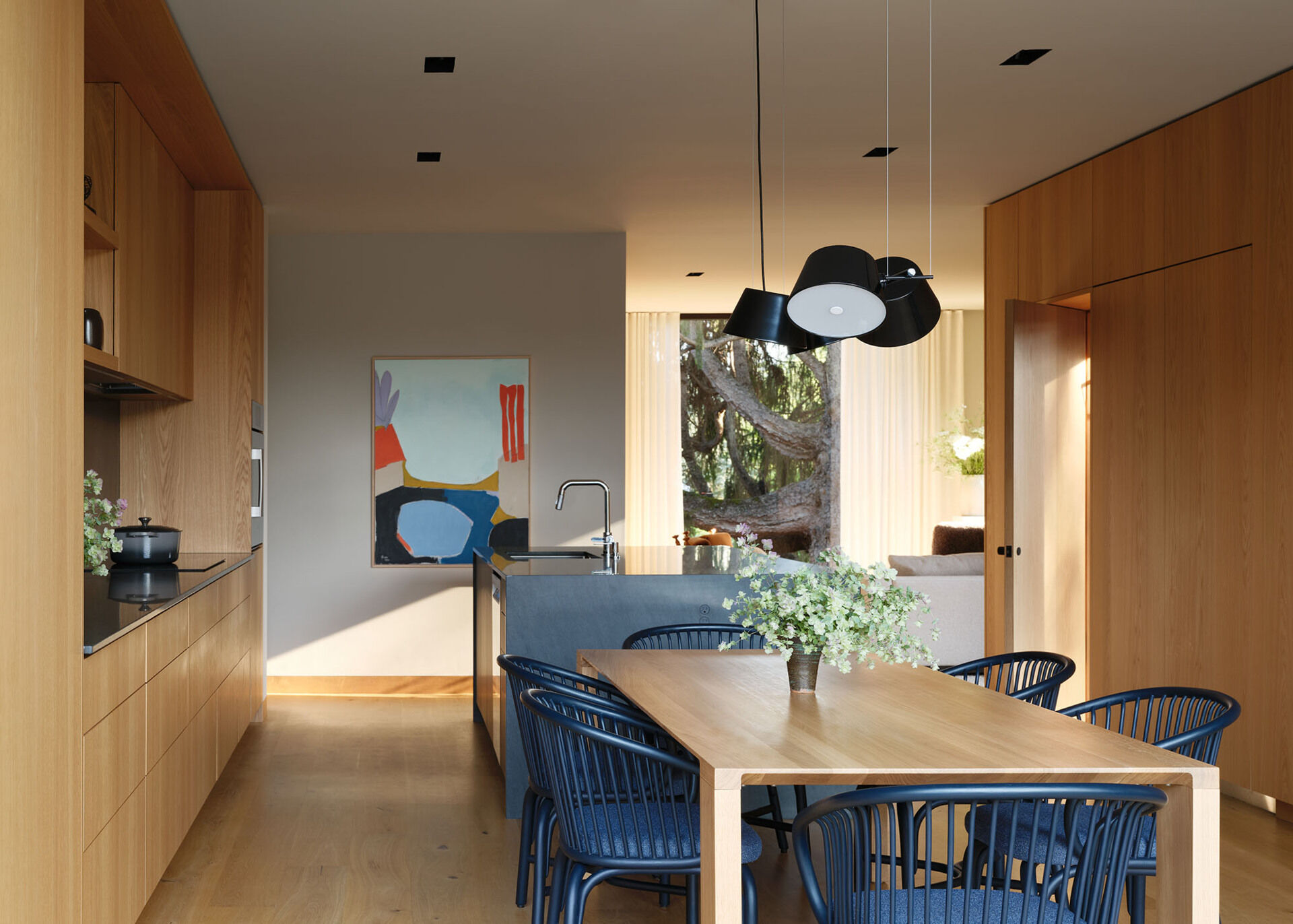 An open kitchen and dining area becomes the social center of the home, designed for everyday family life and connection to the outdoors.