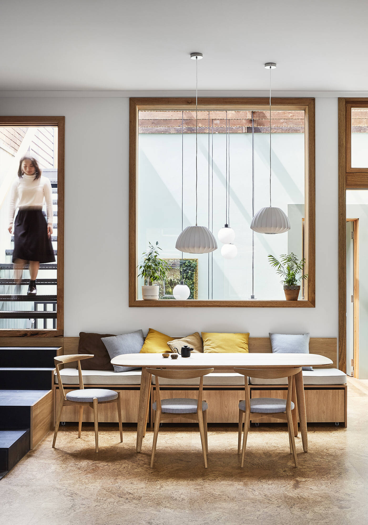 Built-in bench seating in the dining area leads directly to a sunlit rooftop deck.