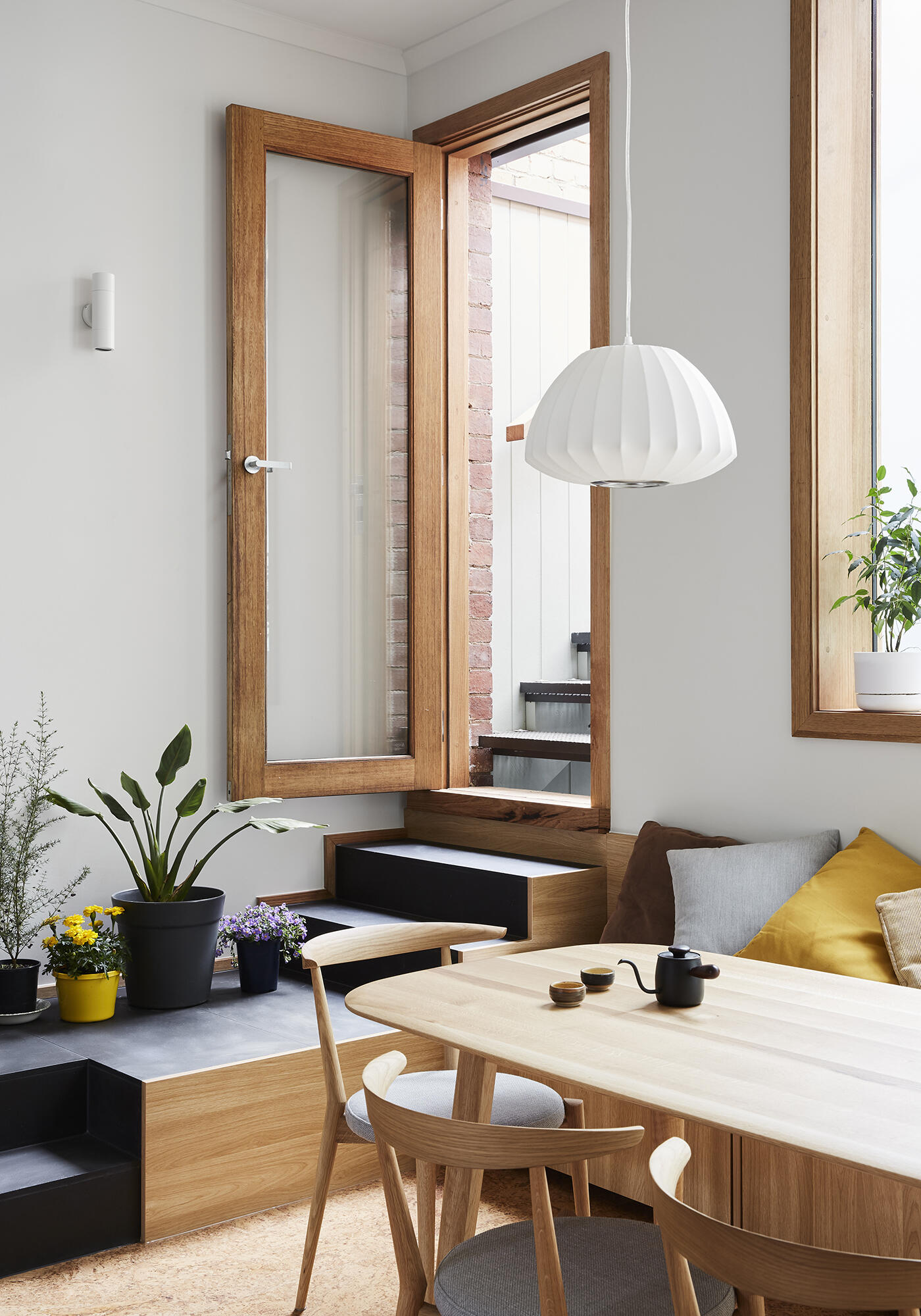 Built-in bench seating in the dining area leads directly to a sunlit rooftop deck.