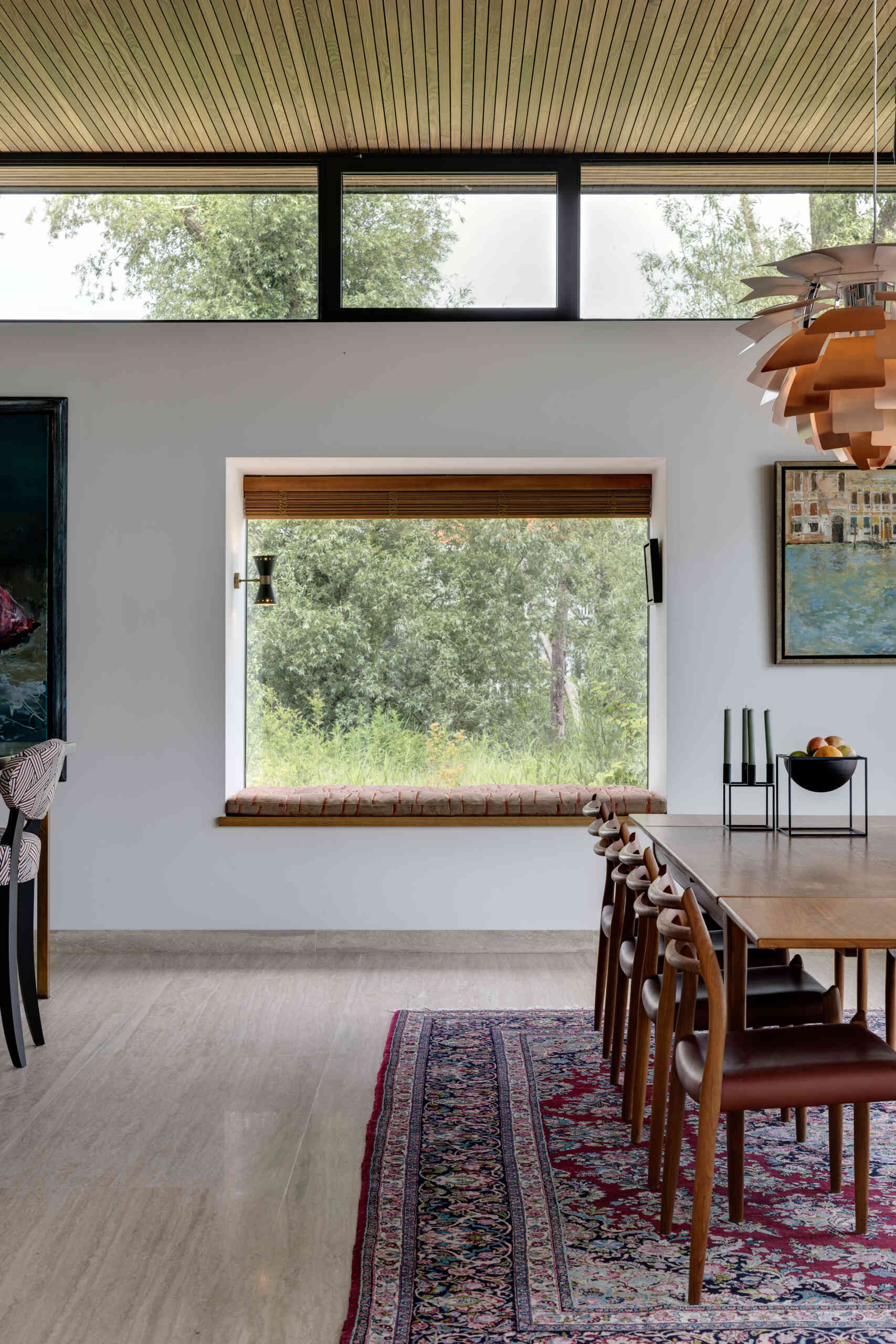 The dining space sits within the open plan, connected through clean sightlines to both patio and rear views. A window seat offers a generous outlook over the garden, creating a calm place to relax.