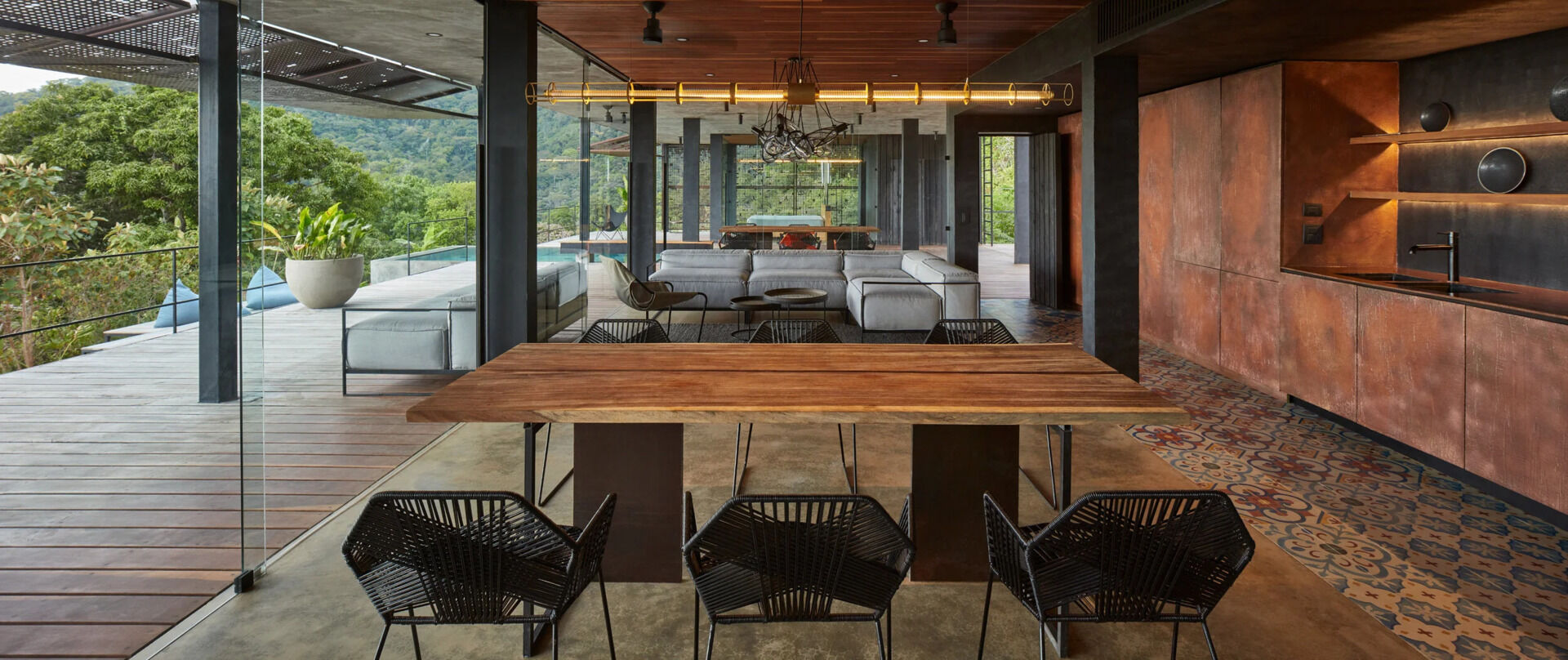 Warm earth tones, a solid wood dining table and a suspended wood ceiling define the open plan living space of this Costa Rican jungle villa.