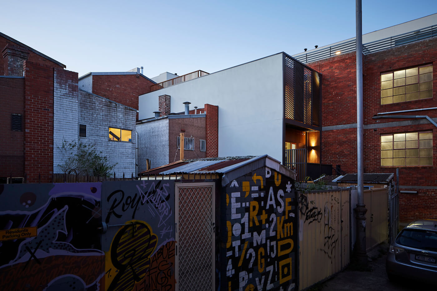 The heritage facade remains intact, but diagonal black screens and laneway steps hint at the modern renovation within.