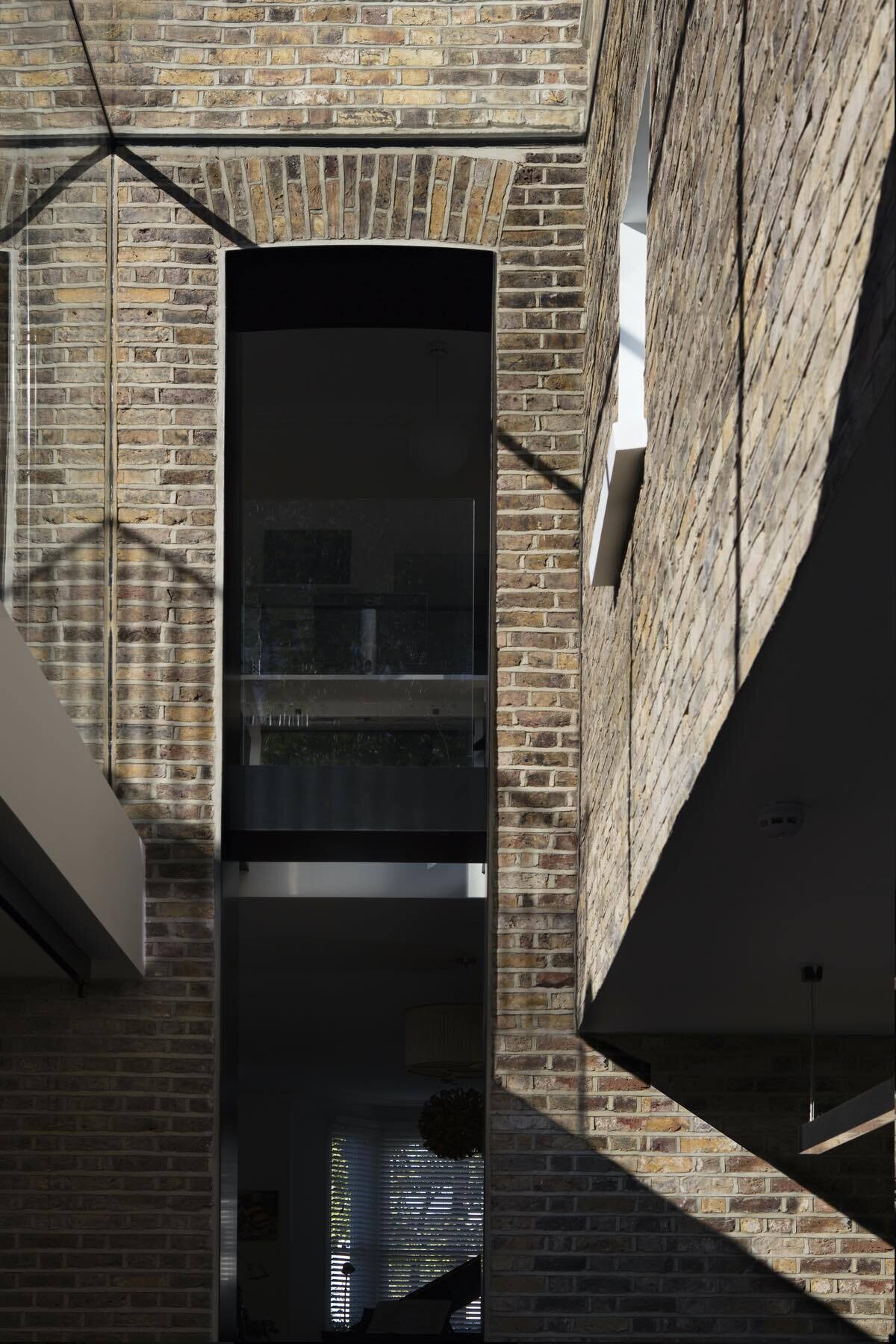 A dramatic double height frameless glass extension transforms a traditional London Victorian home into a light filled contemporary space.