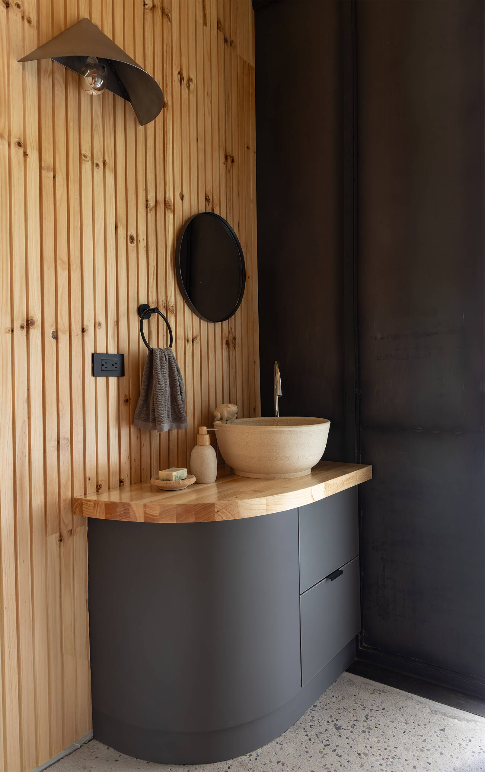 Wet areas are compact and integrated into the structural rhythm, with custom built-in elements crafted on site.