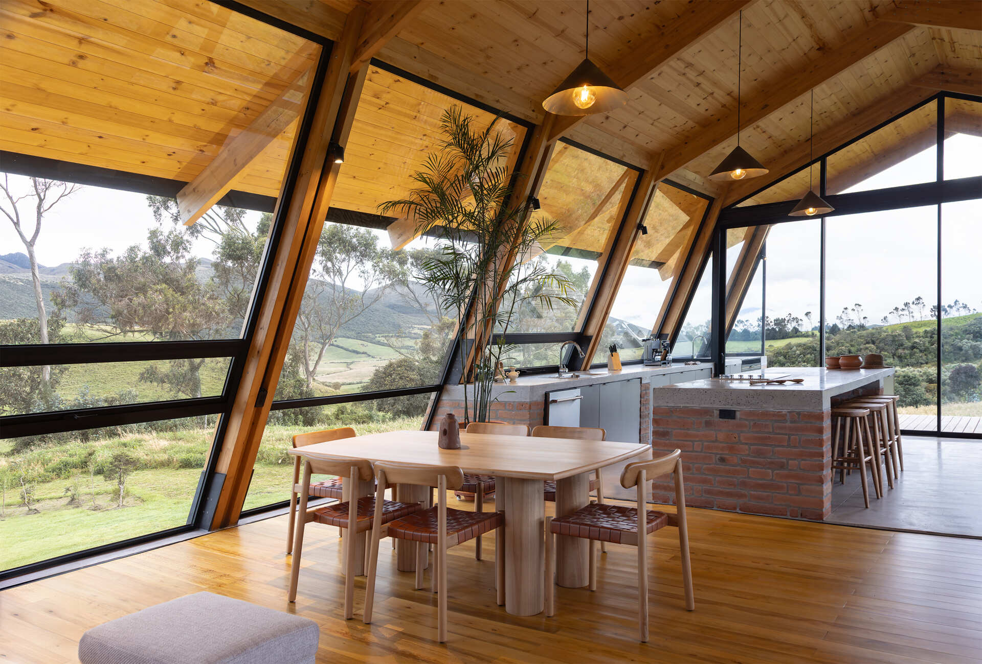 An elevated great room opens to meadows and volcanoes. Living, dining, and kitchen share one expansive level designed for daily life above the terrain.