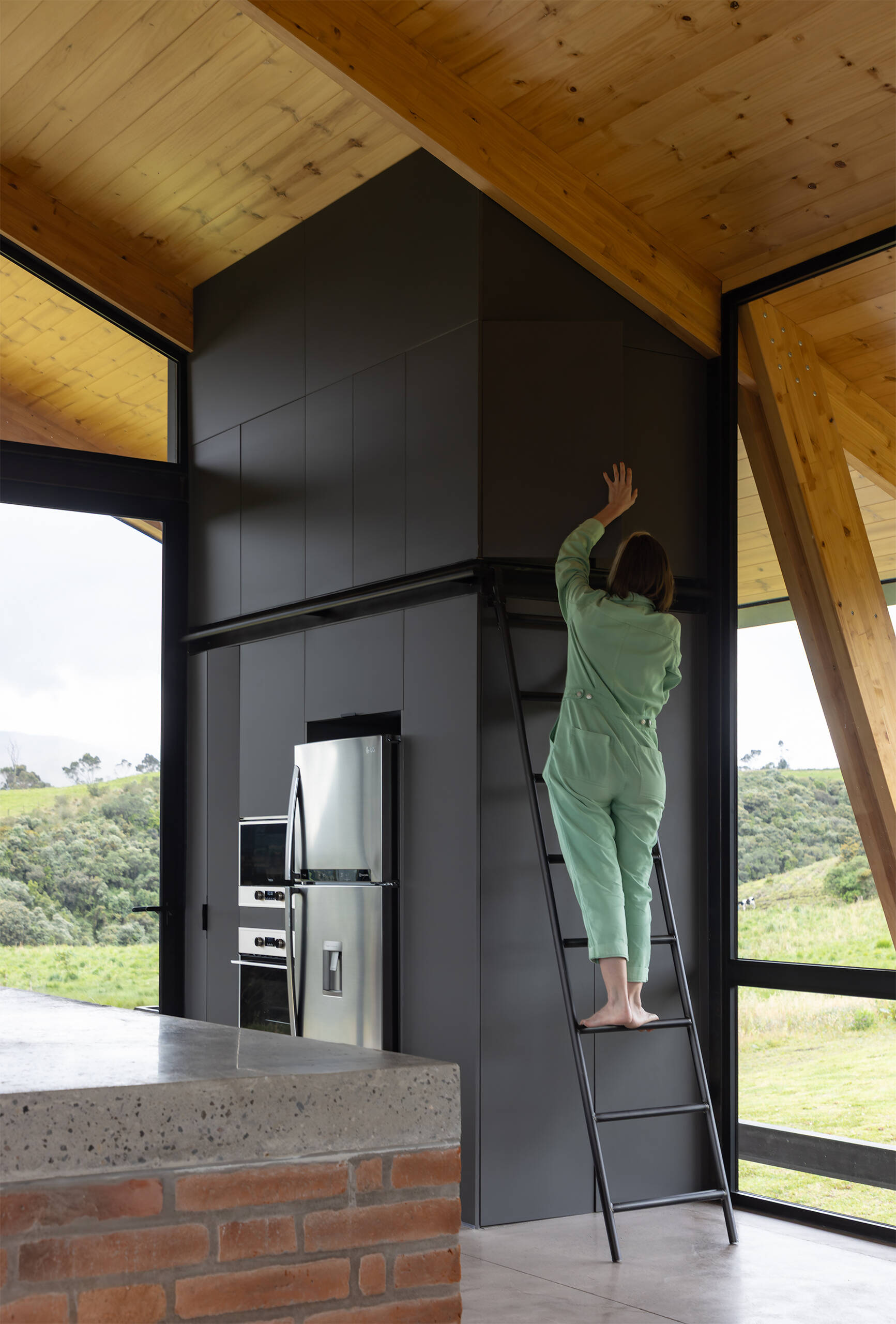 An elevated great room opens to meadows and volcanoes. Living, dining, and kitchen share one expansive level designed for daily life above the terrain.