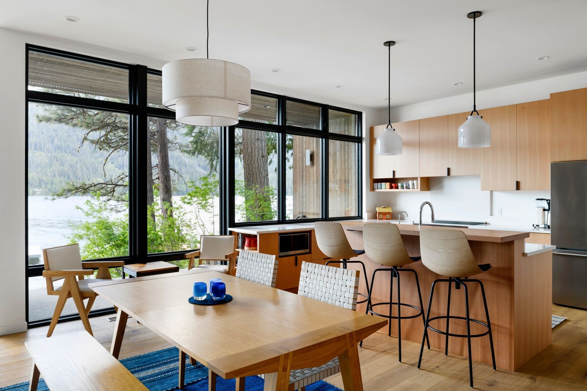 A modern wood and white kitchen with an island and breakfast bar.