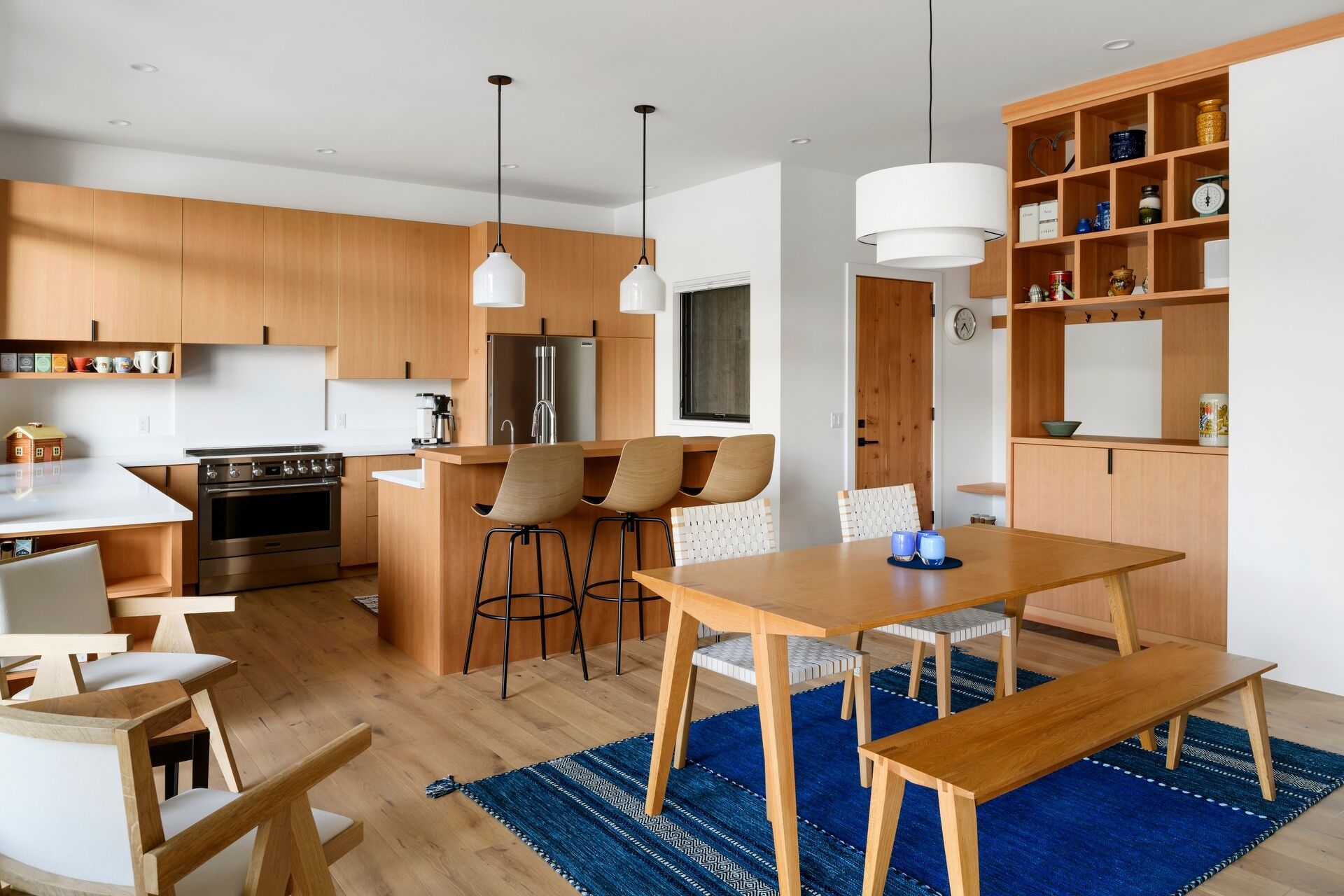 A modern wood and white kitchen with an island and breakfast bar.