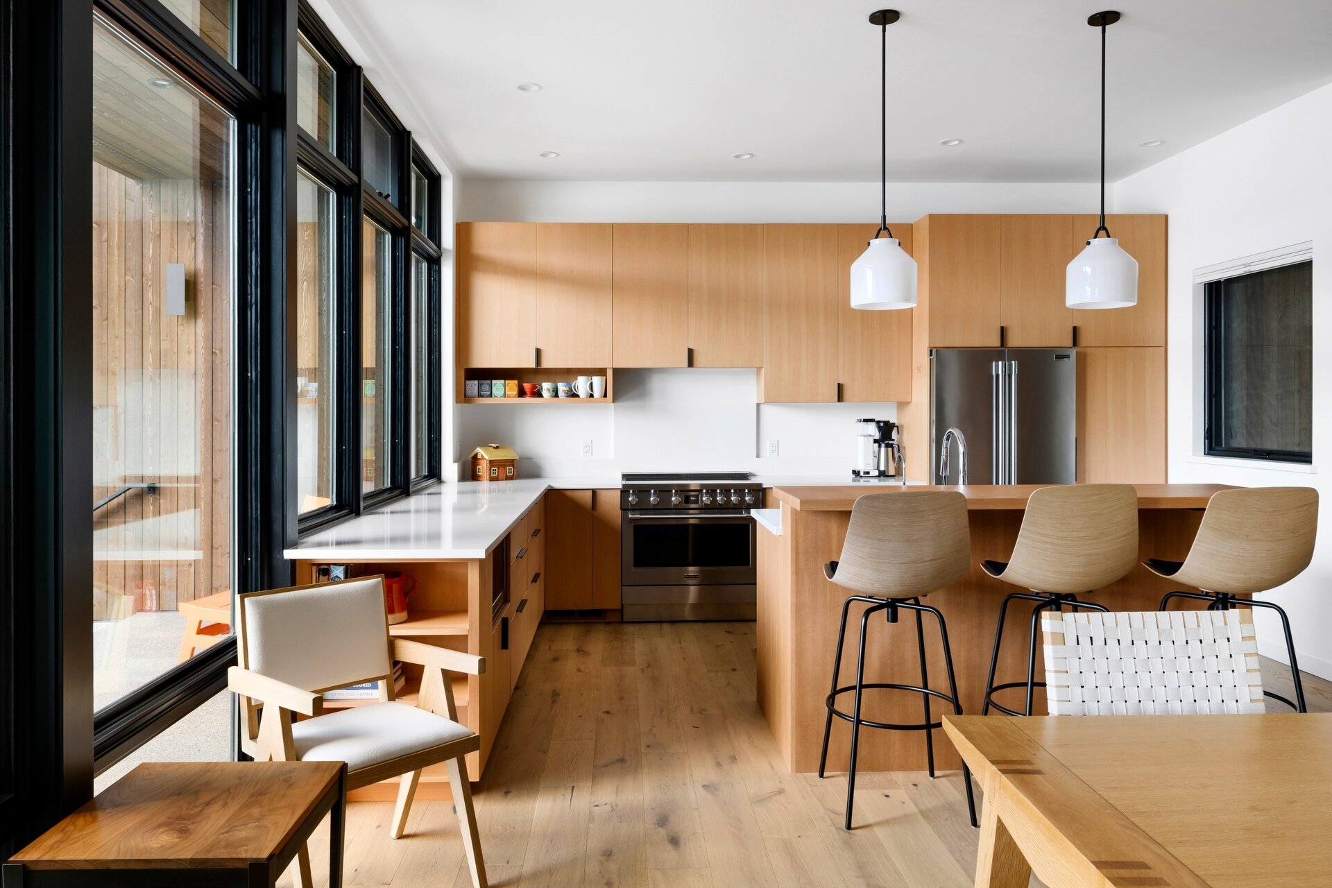 A modern wood and white kitchen with an island and breakfast bar.
