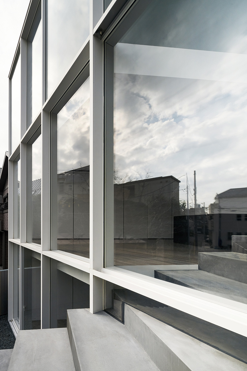 A minimalist Tokyo home where a single staircase starts in the garden, continues indoors, and rises toward a skylight, turning everyday movement into the home’s most striking architectural feature.