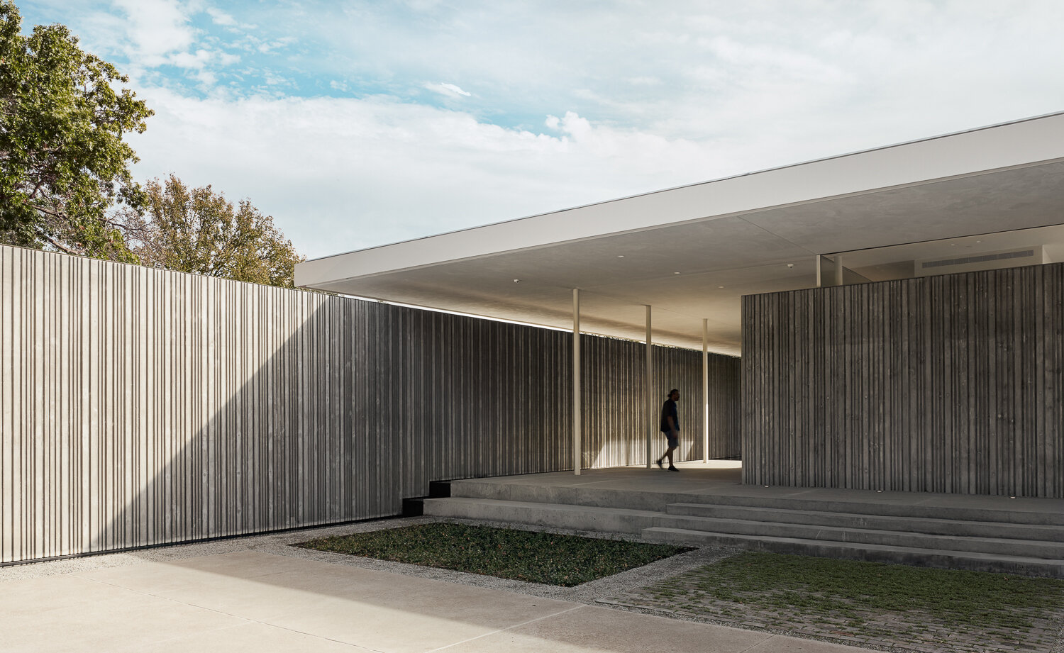 Custom-fabricated formwork gives these concrete walls their distinctive corrugated texture, creating depth, pattern, and ever-changing shadows throughout the day.