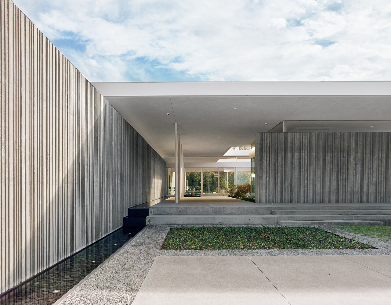 Custom-fabricated formwork gives these concrete walls their distinctive corrugated texture, creating depth, pattern, and ever-changing shadows throughout the day.
