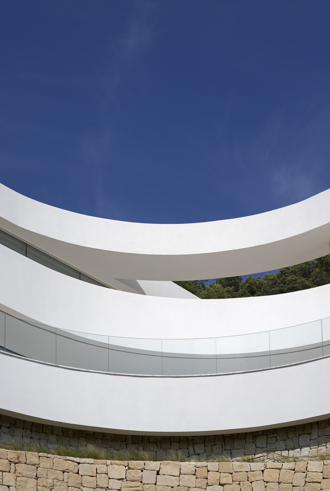 Plataformas serpenteantes deslizantes definen esta casa escultórica en la Comunidad Valenciana, diseñada para seguir la pendiente natural y maximizar las vistas ininterrumpidas al mar.