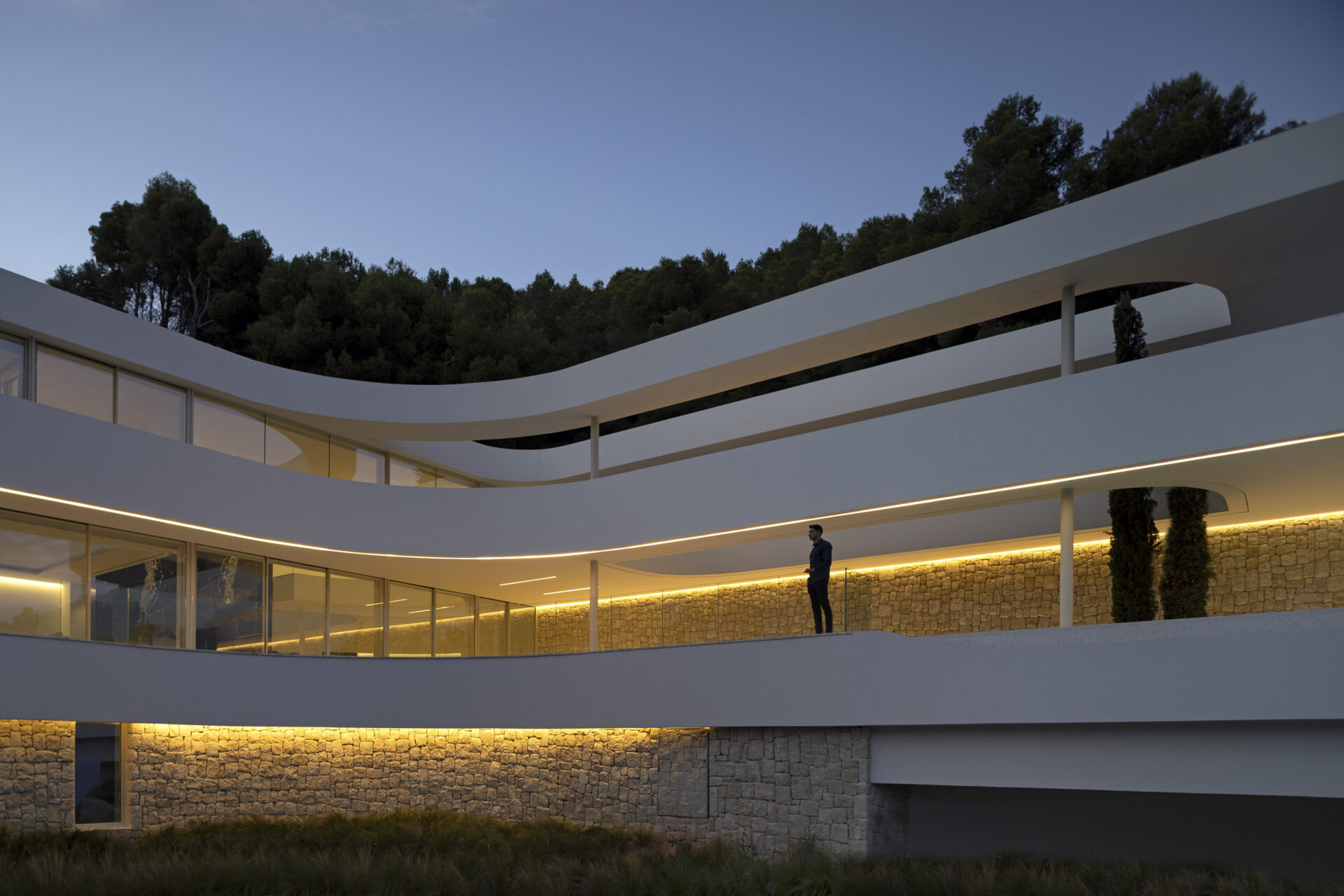 Plataformas serpenteantes deslizantes definen esta casa escultórica en la Comunidad Valenciana, diseñada para seguir la pendiente natural y maximizar las vistas ininterrumpidas al mar.