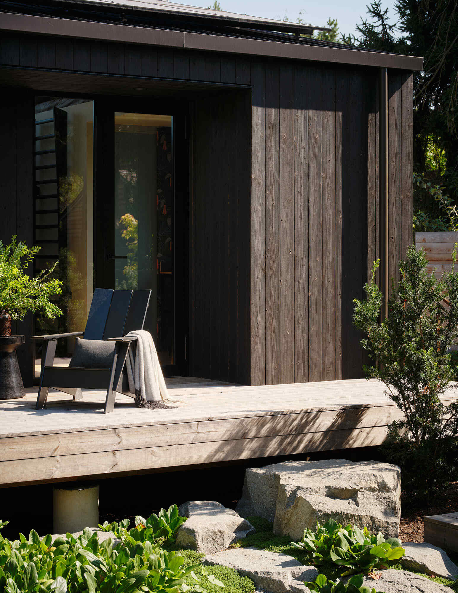An elevated deck and informal stone steps create a flexible link between the main house and the DADU, allowing the layout to evolve over time.