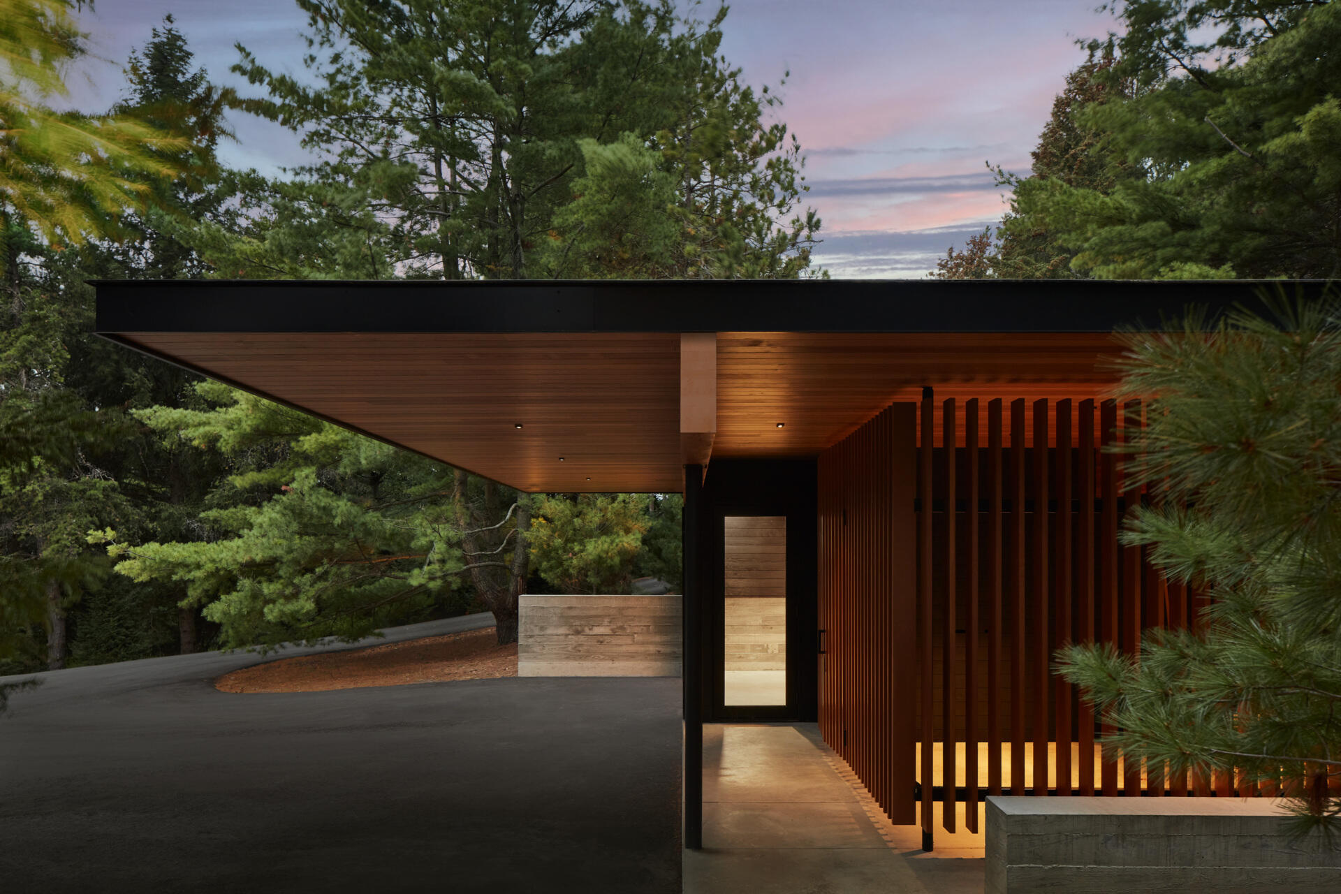 Muros bajos apilados de granito local organizan la residencia y hacen referencia a los tradicionales bordes de piedra del campo. El revestimiento de fresno termomodificado, la madera de origen local, el hormigón, la piedra y los detalles en metal negro crean una apariencia fuerte y duradera.