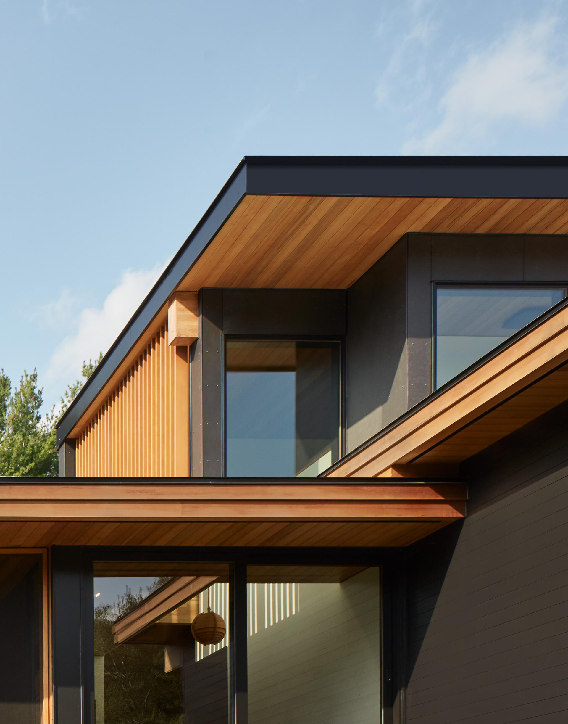 Los espacios interiores se extienden hacia el exterior hacia vistas y campos. Las vigas expuestas abarcan el plano del techo, permitiendo que la brisa fluya libremente por toda la casa, dando la bienvenida a familiares, amigos y perros.