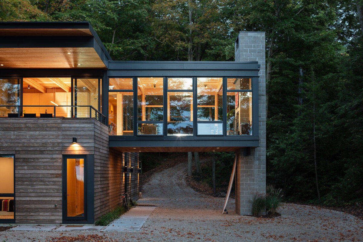 A modern home with a suspended living room opens sightlines through the site while creating sheltered space below