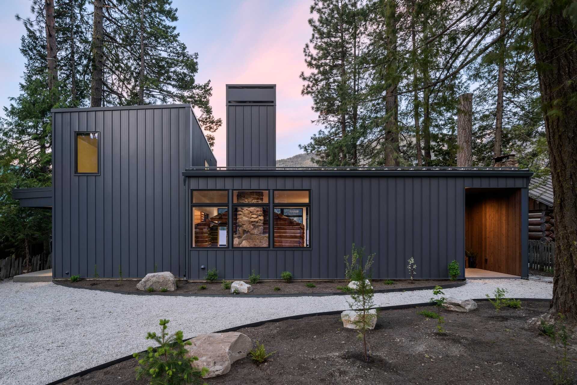 From the entry, the original cabin is visible behind glass, immediately setting the tone for the entire home.