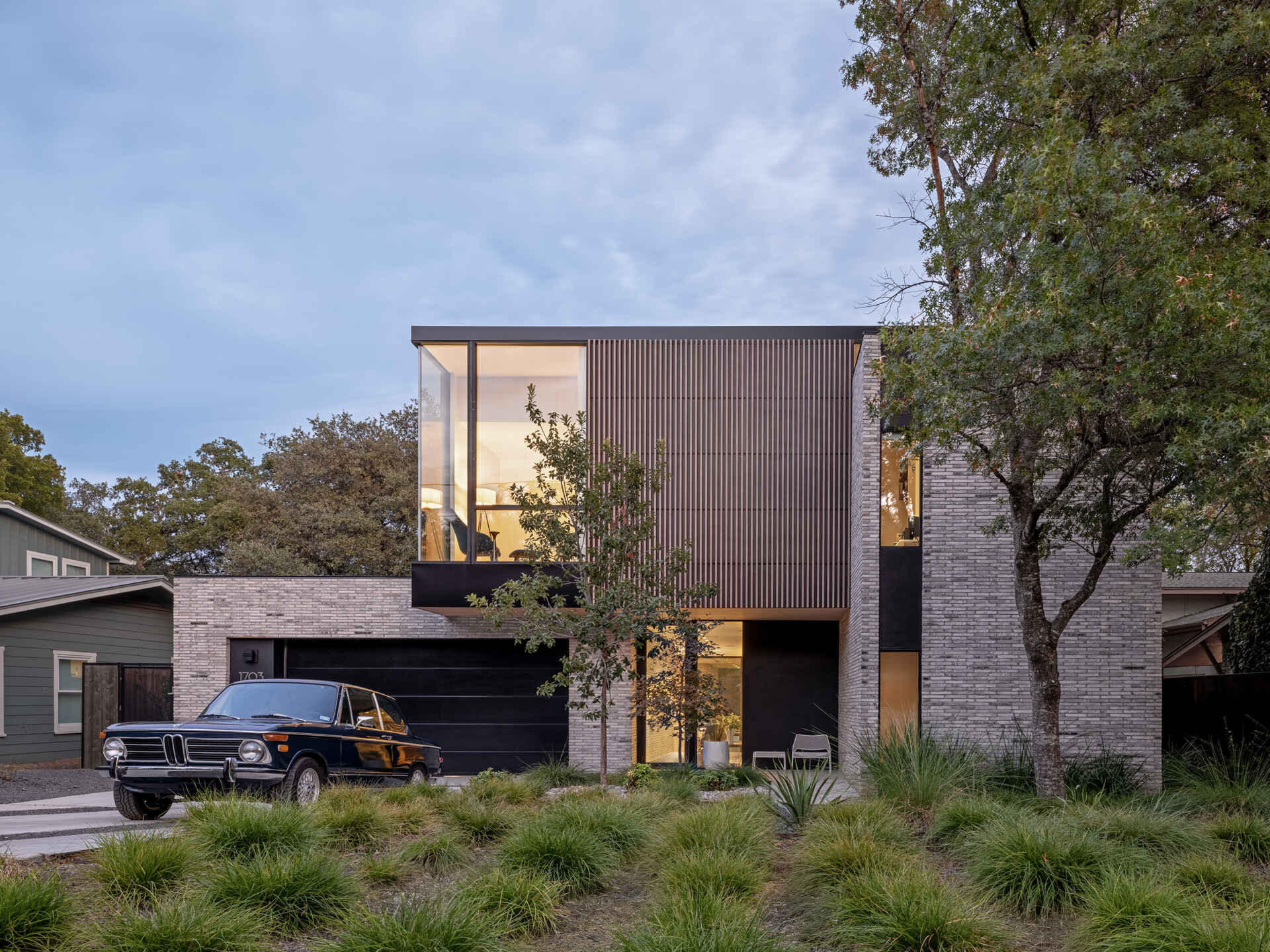 A modern infill home that breaks down its mass with brick, vertical wood battens, and carefully stepped volumes.
