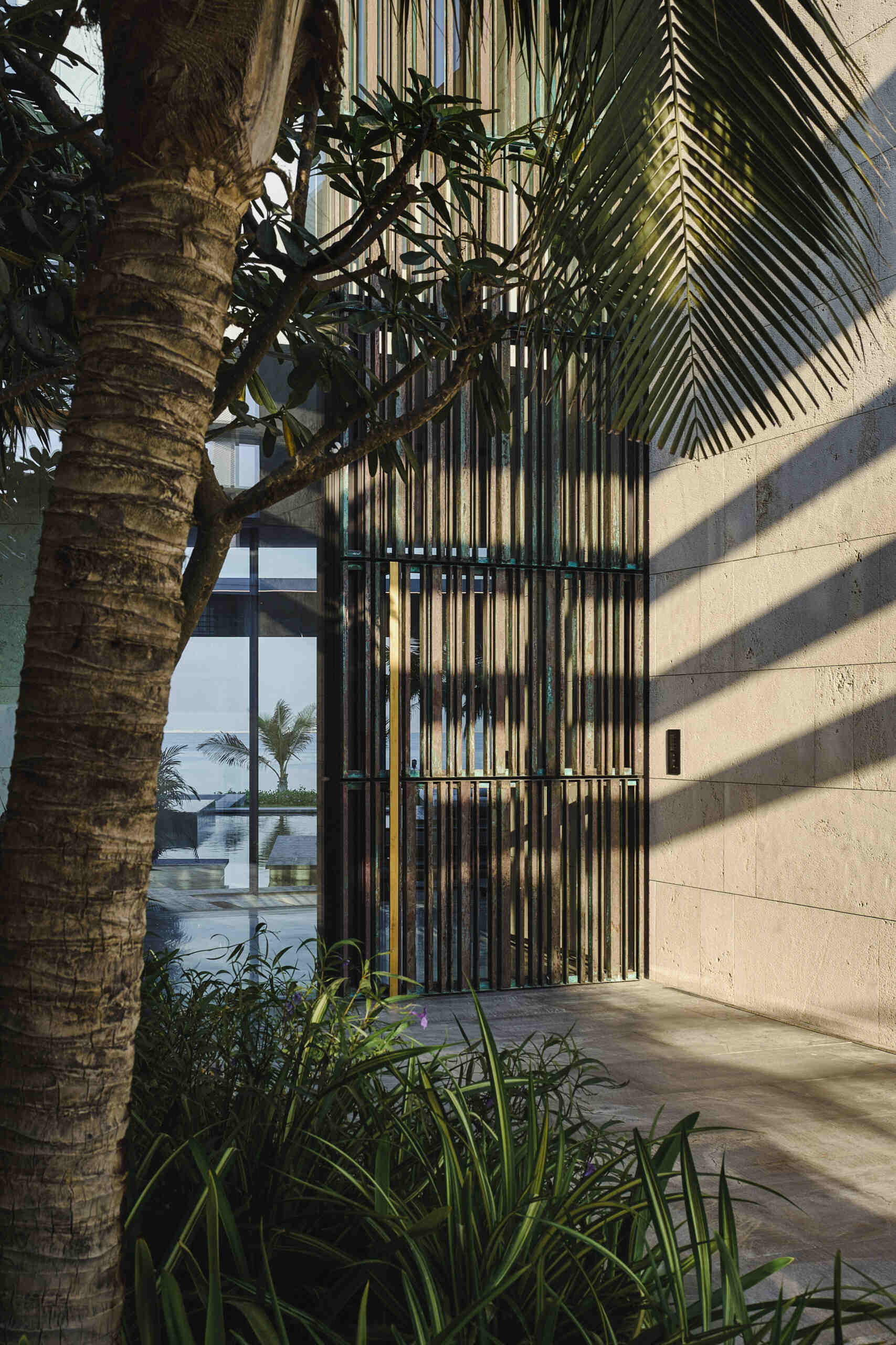 The entry sequence balances seclusion and transparency through textured finishes and filtered light. Screens soften the street edge while guiding visitors into a calm, considered interior.