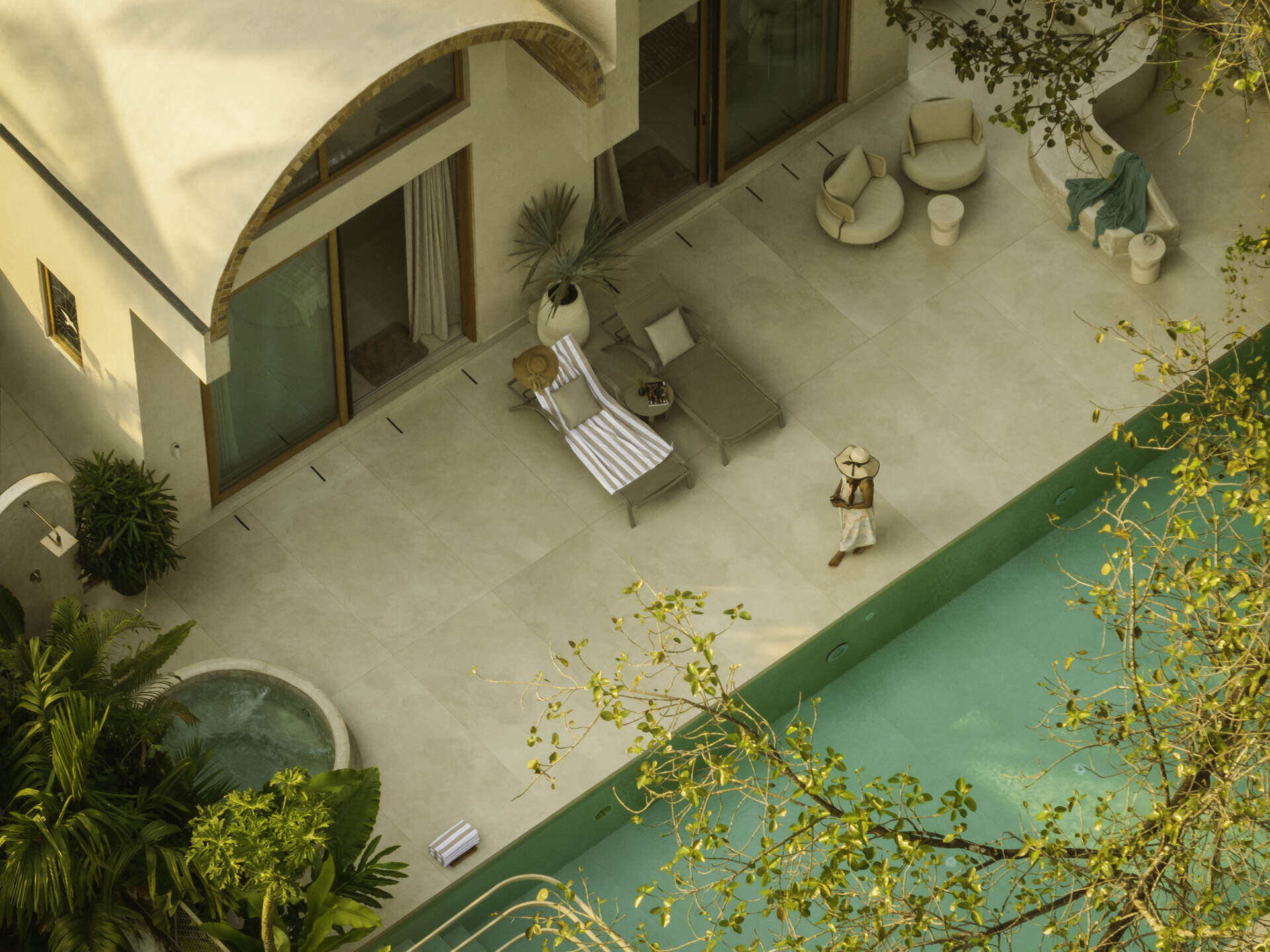 A stepped water channel leads to a reflective pool overlooking open fields in Goa. Seamless indoor-outdoor flooring and an in-situ concrete jacuzzi create a calm, continuous connection between architecture and landscape.