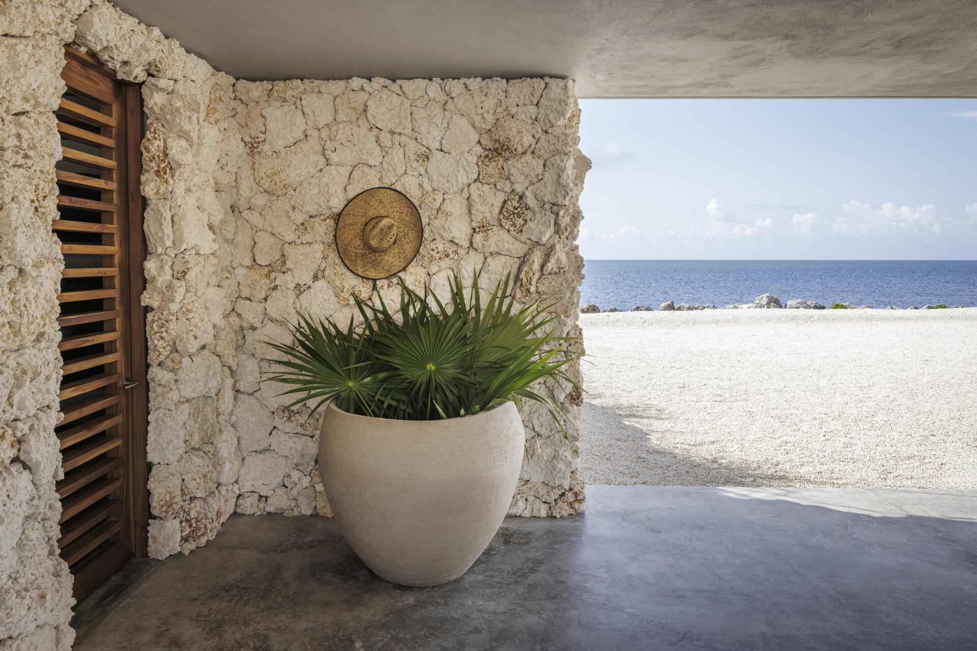 Louvered screens and solid materials balance shading, cooling, and protection in a hurricane-prone environment.