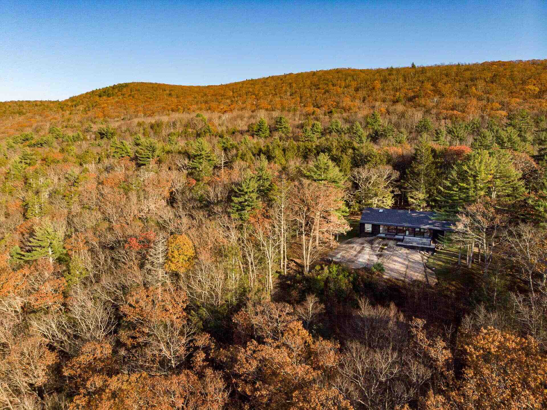 A modern home in Cornwall, Connecticut, built directly on a dramatic rock ledge. Inspired by local barns and the historic West Cornwall Covered Bridge, this forest retreat blends charred wood siding with contemporary design.