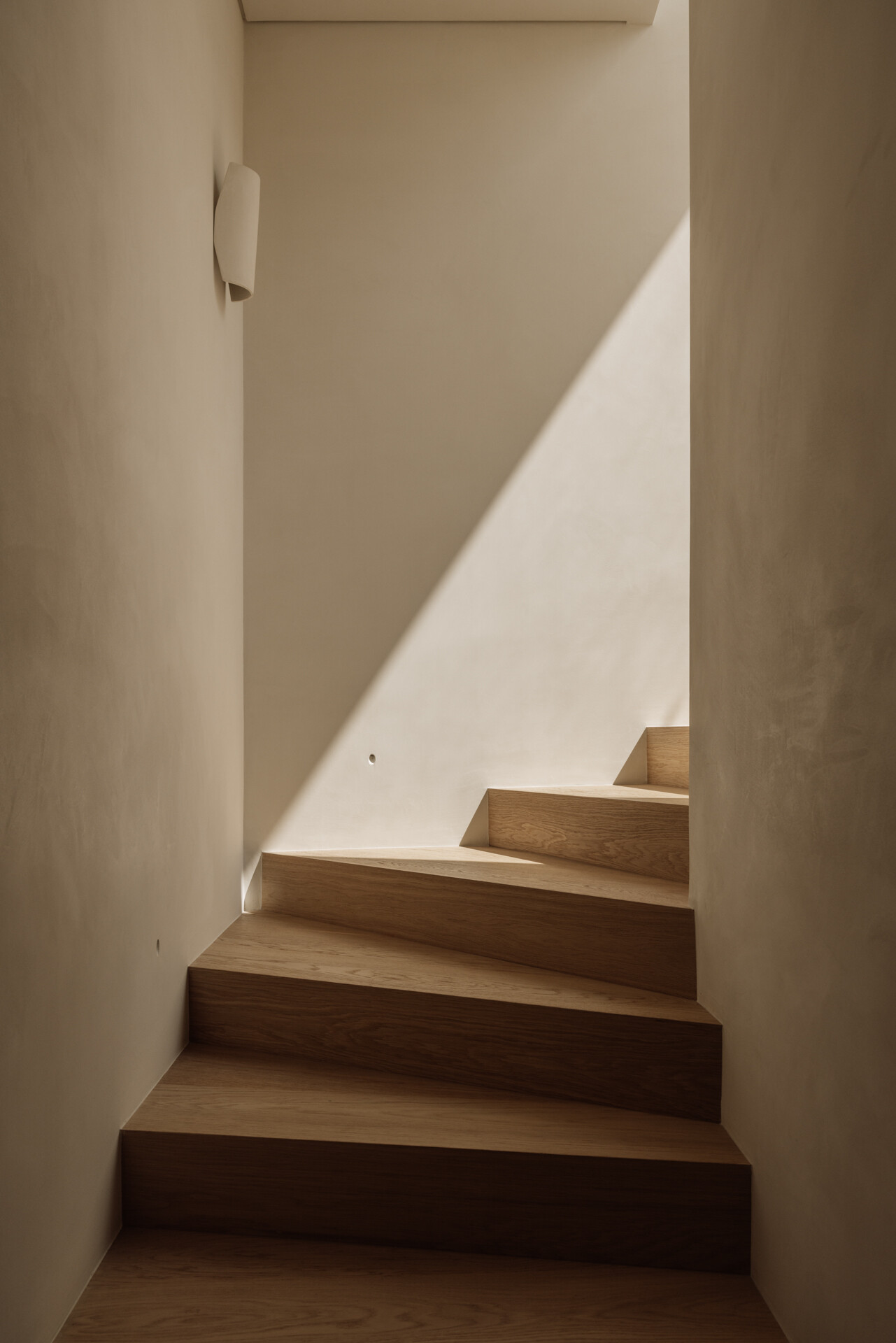 An internal staircase connecting two levels of this 230 sq m duplex, maintaining light and visual connection throughout.