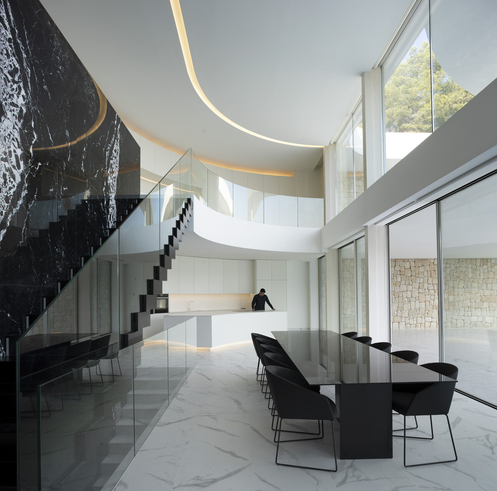 Un sorprendente espacio de doble altura y una escalera de mármol negro Marquina son la pieza central de esta casa en la ladera de una colina en Jávea.