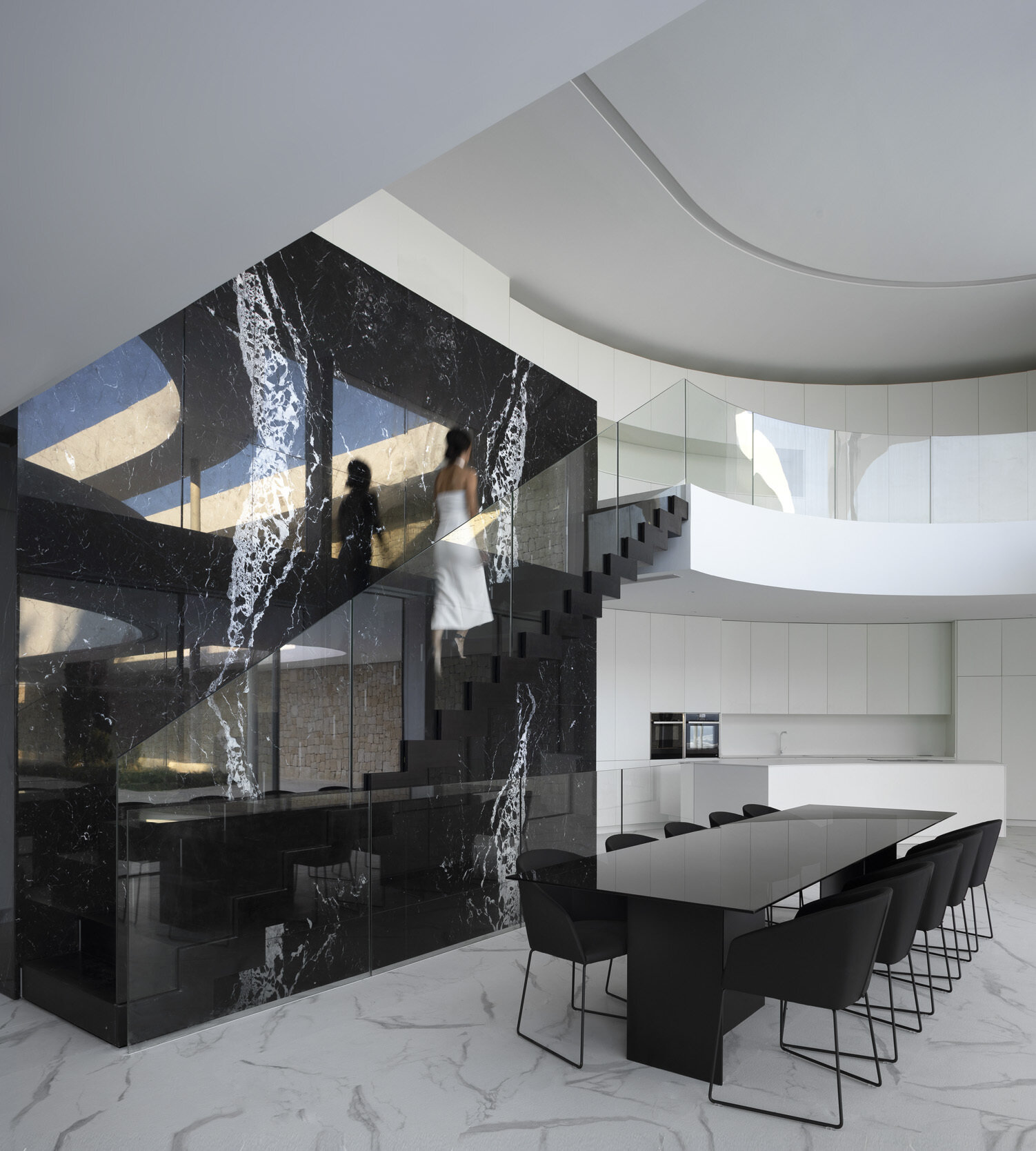 Un sorprendente espacio de doble altura y una escalera de mármol negro Marquina son la pieza central de esta casa en la ladera de una colina en Jávea.