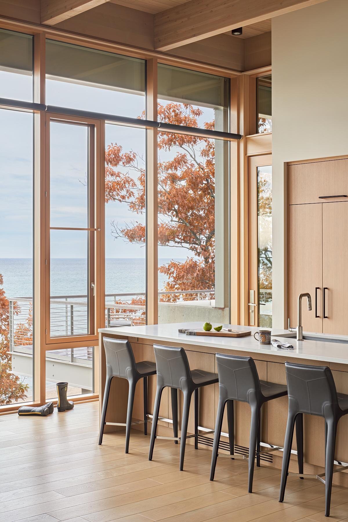 The kitchen overlooks the lake, combining function with breathtaking scenery. Integrated with the dining and living areas, it’s designed for hosting large gatherings or enjoying everyday meals with a view.