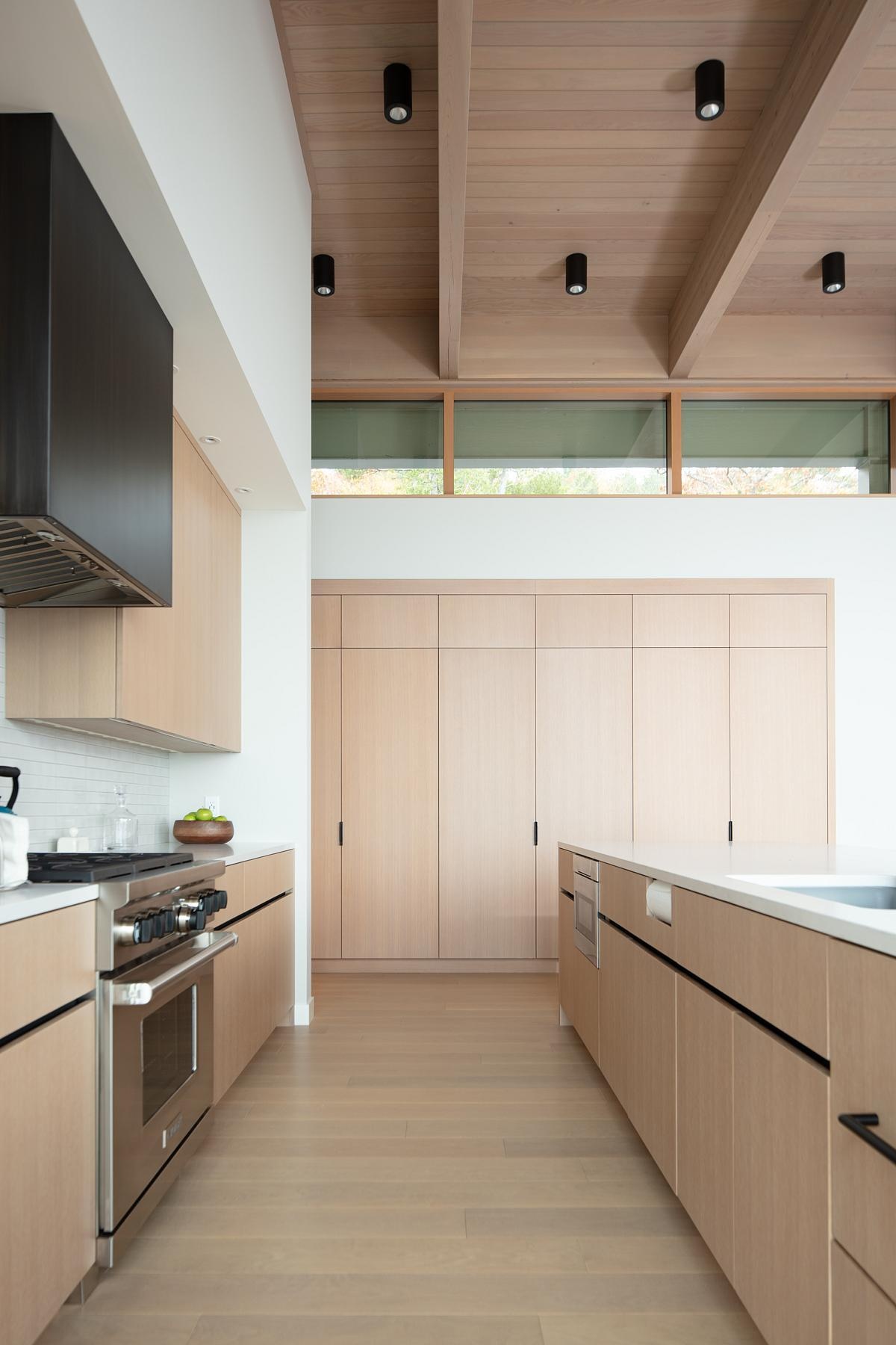 The kitchen overlooks the lake, combining function with breathtaking scenery. Integrated with the dining and living areas, it’s designed for hosting large gatherings or enjoying everyday meals with a view.