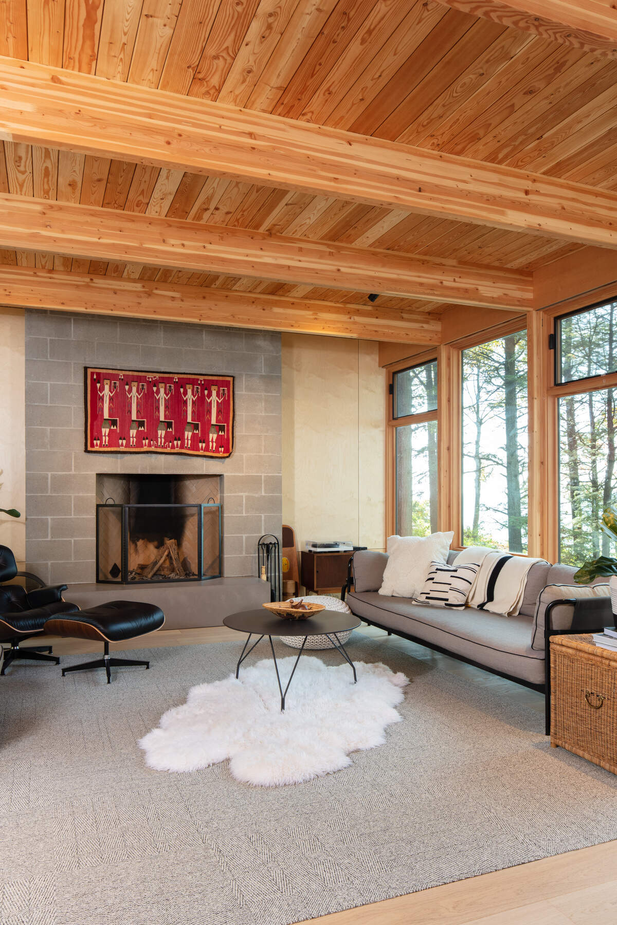 The elevated living room becomes the center of the house and the key to preserving the view. By suspending this volume above grade, the design opens a clear visual path to the water while shaping a sheltered outdoor area below. That space can be used to escape a rain shower, store gear, or prepare for time outdoors.