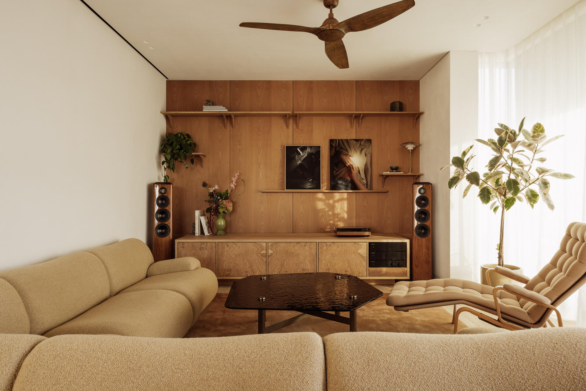 A sunlit open plan living area in Athens defined by furniture and light partitions, with large openings that frame trees and city views.