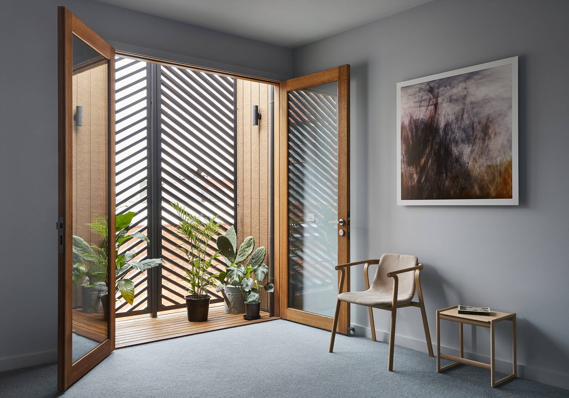 Wood-framed glass doors open to a discreet balcony behind slatted panels.