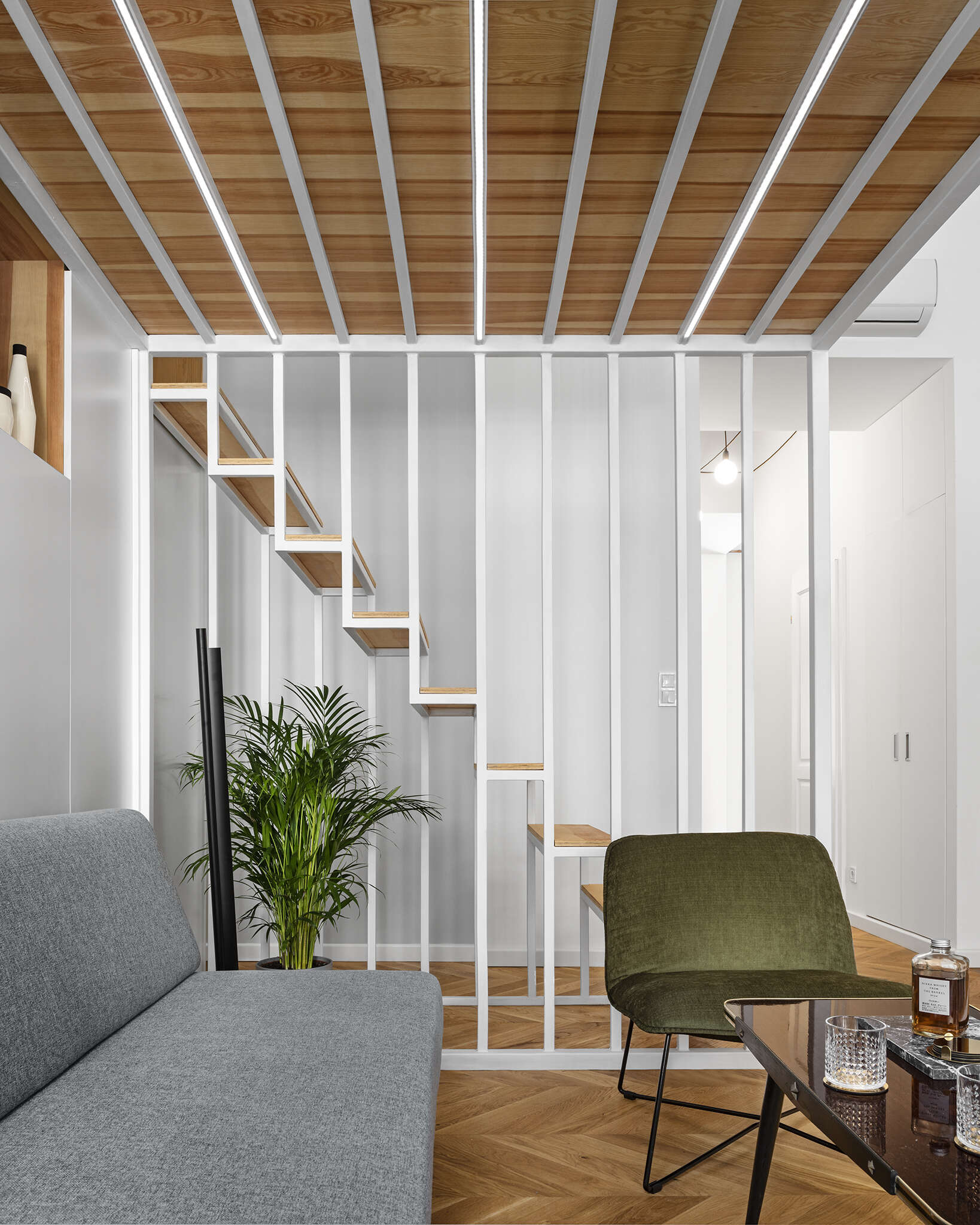 A sculptural staircase leading to a mezzanine, featuring a built in bookcase that blends storage with architectural flow.