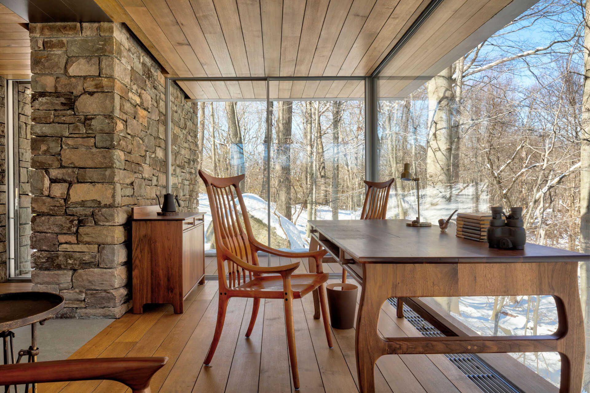 Glass-enclosed writer’s space with cantilevered views over a Connecticut ravine, designed for creativity and peace.