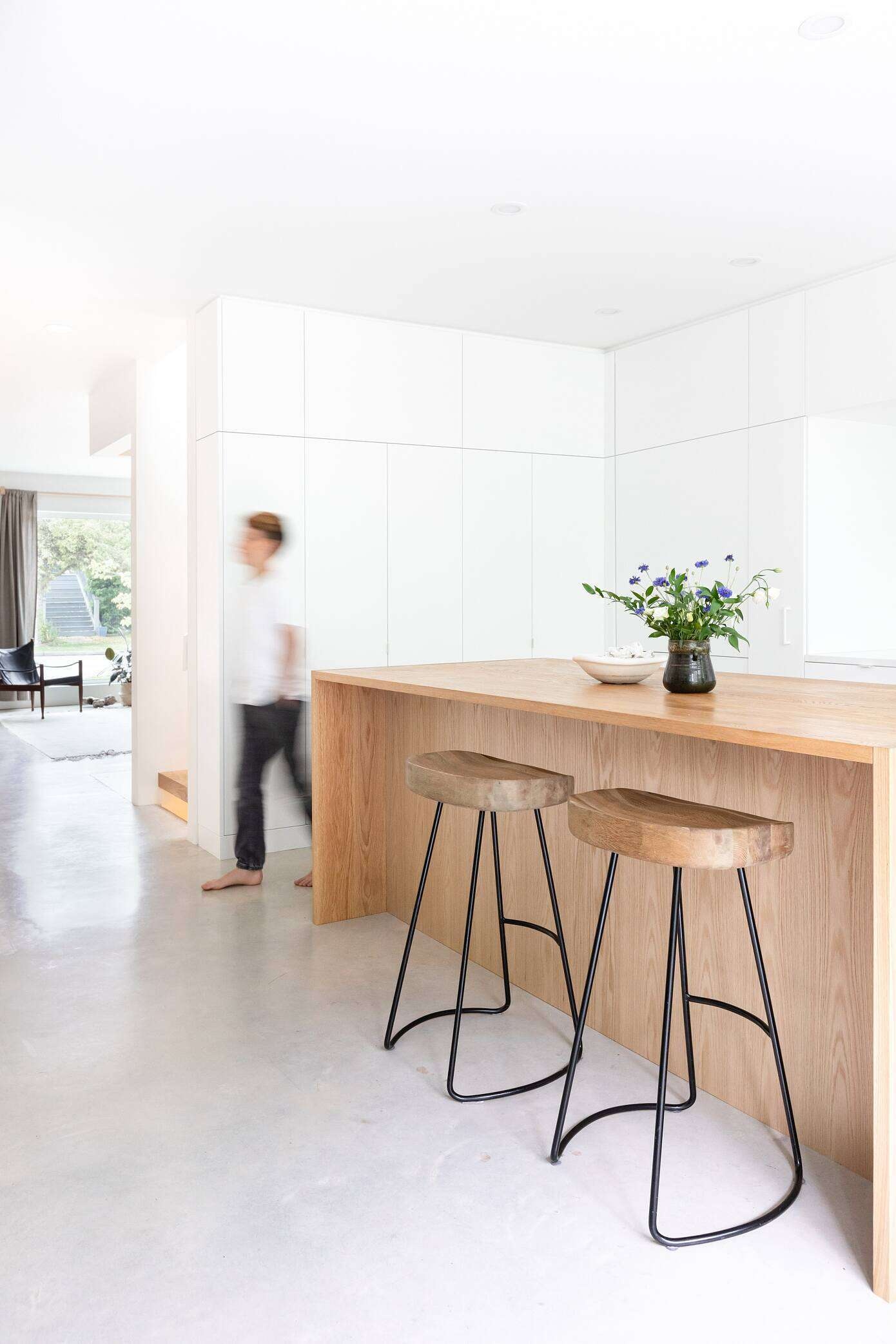 A wood island and seamless white cabinetry bring warmth and simplicity to this light filled modern kitchen.