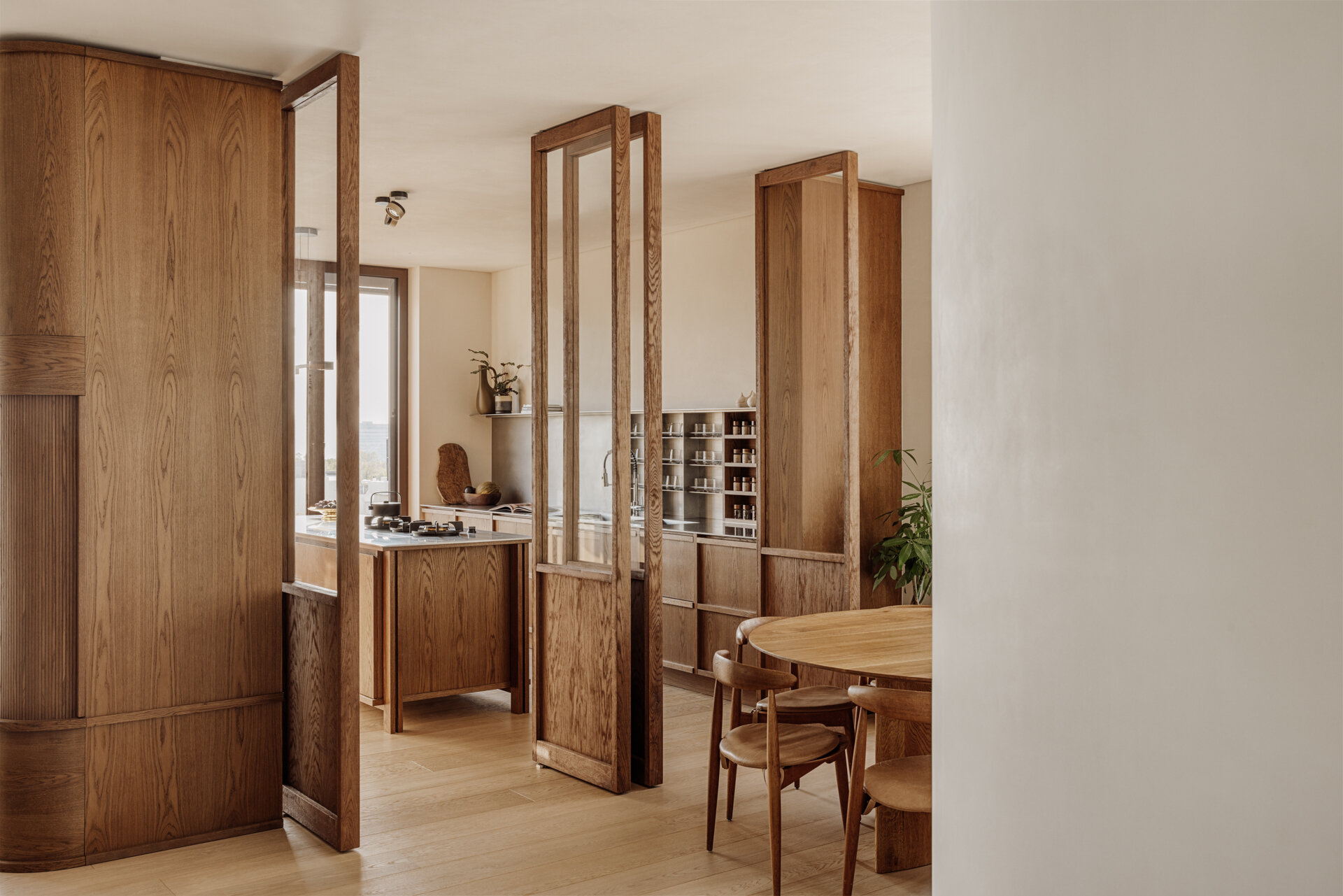 The kitchen is generous in scale and designed for entertaining, yet it remains fully integrated into family life. Natural materials define the mood. Marble, wood, textured render, create a layered, tactile palette.