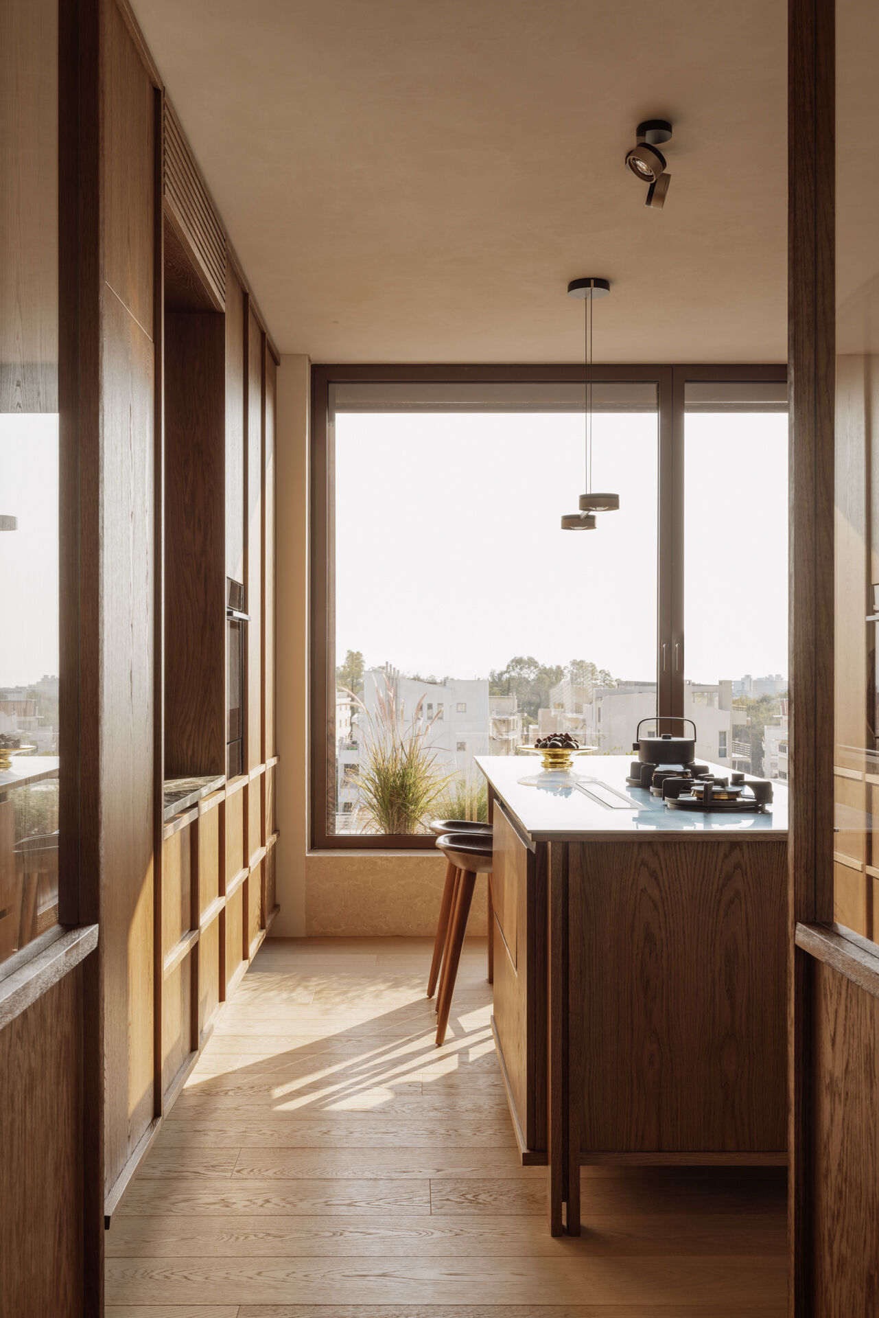 The kitchen is generous in scale and designed for entertaining, yet it remains fully integrated into family life. Natural materials define the mood. Marble, wood, textured render, create a layered, tactile palette.
