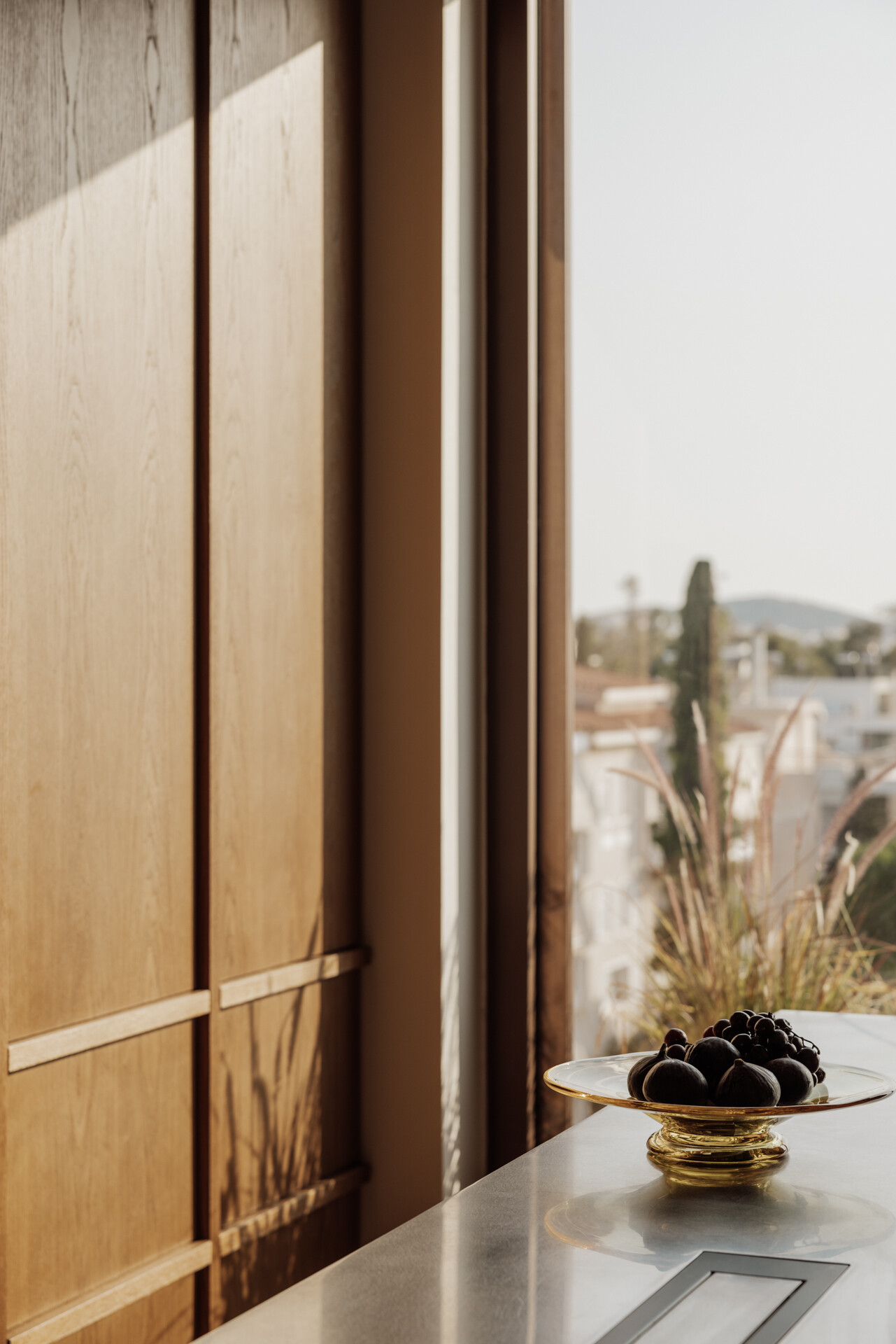 The kitchen is generous in scale and designed for entertaining, yet it remains fully integrated into family life. Natural materials define the mood. Marble, wood, textured render, create a layered, tactile palette.