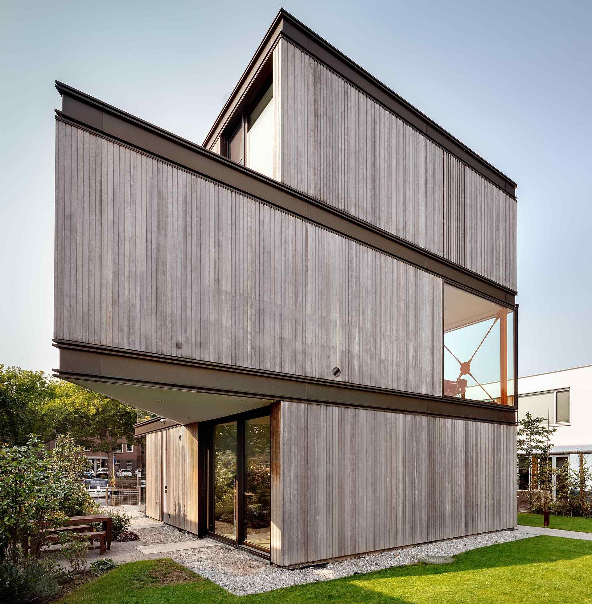 This modern villa in Schiedam features three stacked rectangular floors, with the middle level rotated to create a striking angular form. Wood, metal and glass reference the site’s industrial past while adding a subtle maritime touch.