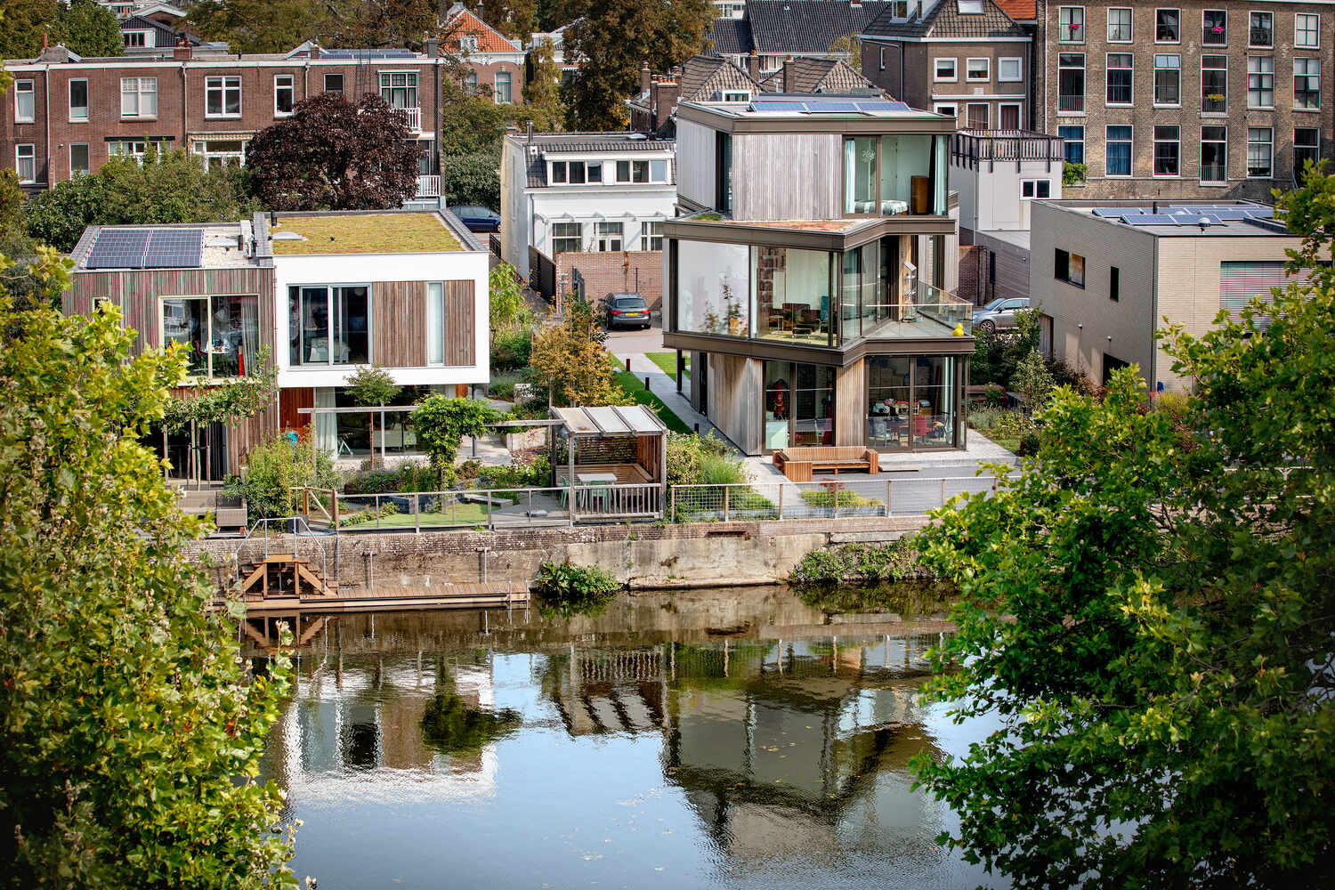 Walls of glass open the dining room to the canal, with a semi recessed balcony positioned to overlook passing boats. The sharp corners and expansive glazing frame uninterrupted waterfront views.