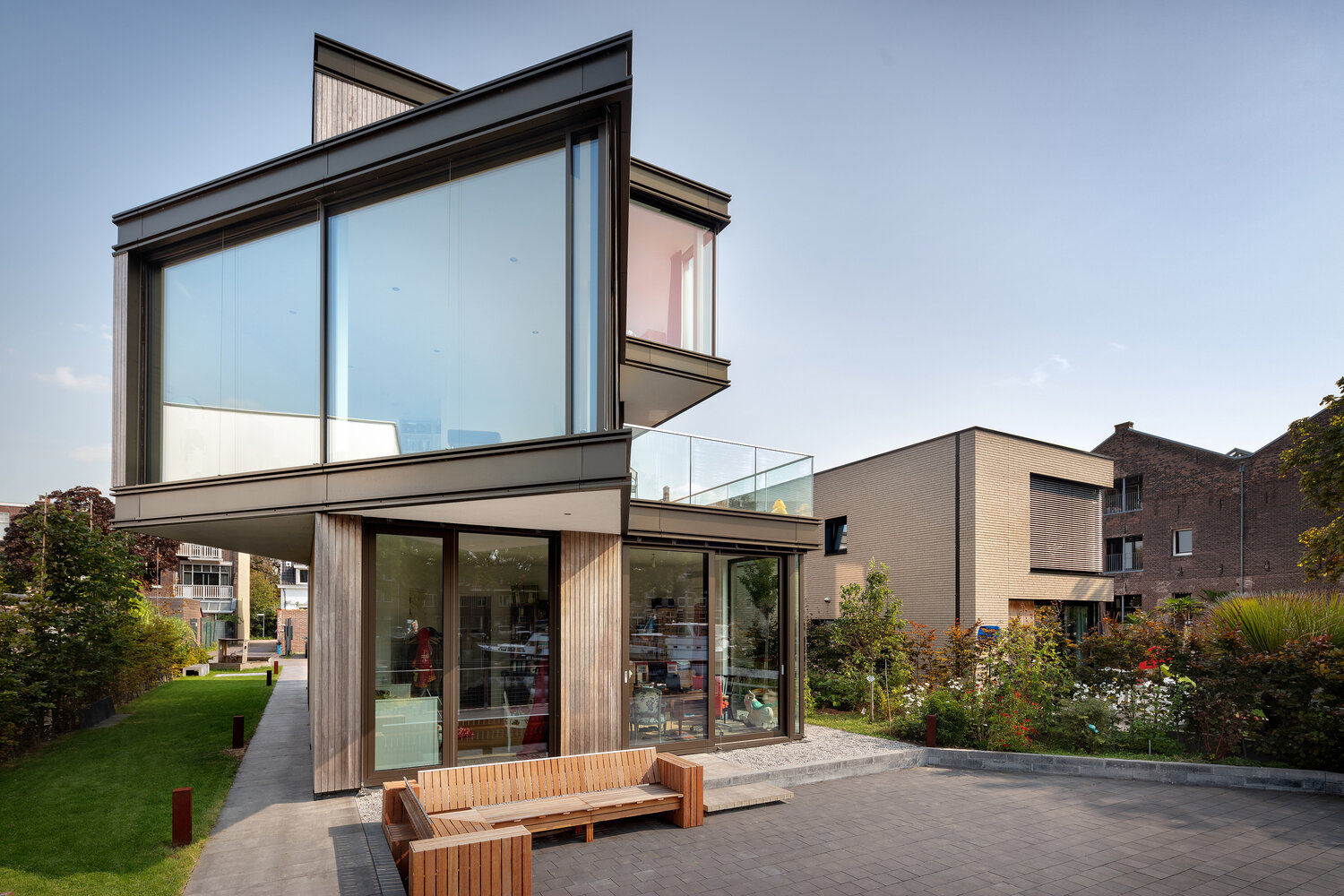Walls of glass open the dining room to the canal, with a semi recessed balcony positioned to overlook passing boats. The sharp corners and expansive glazing frame uninterrupted waterfront views.