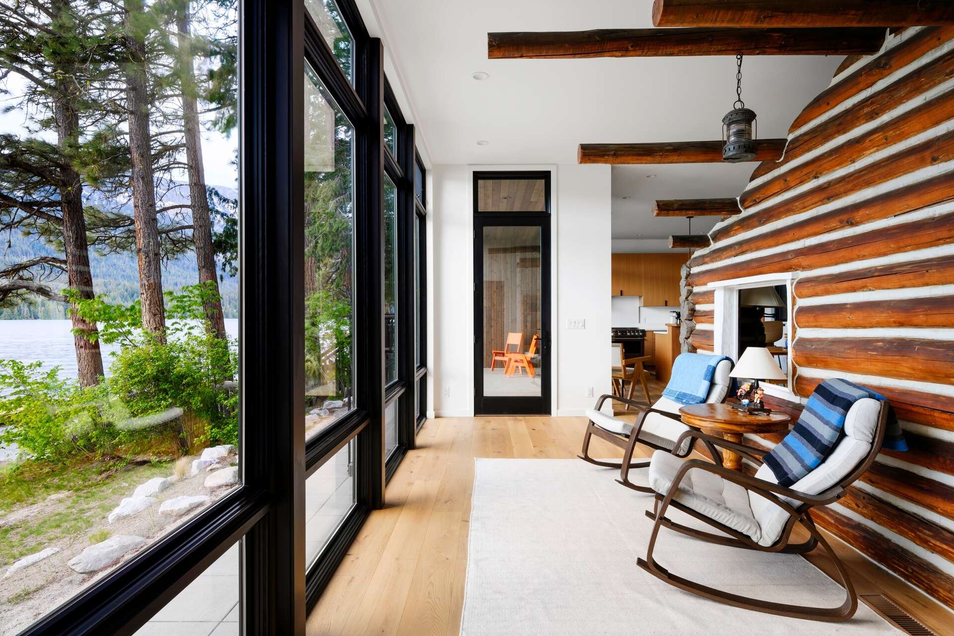 The restored log cabin now serves as the living room in this modern home, complete with original materials and subtle modern lighting.