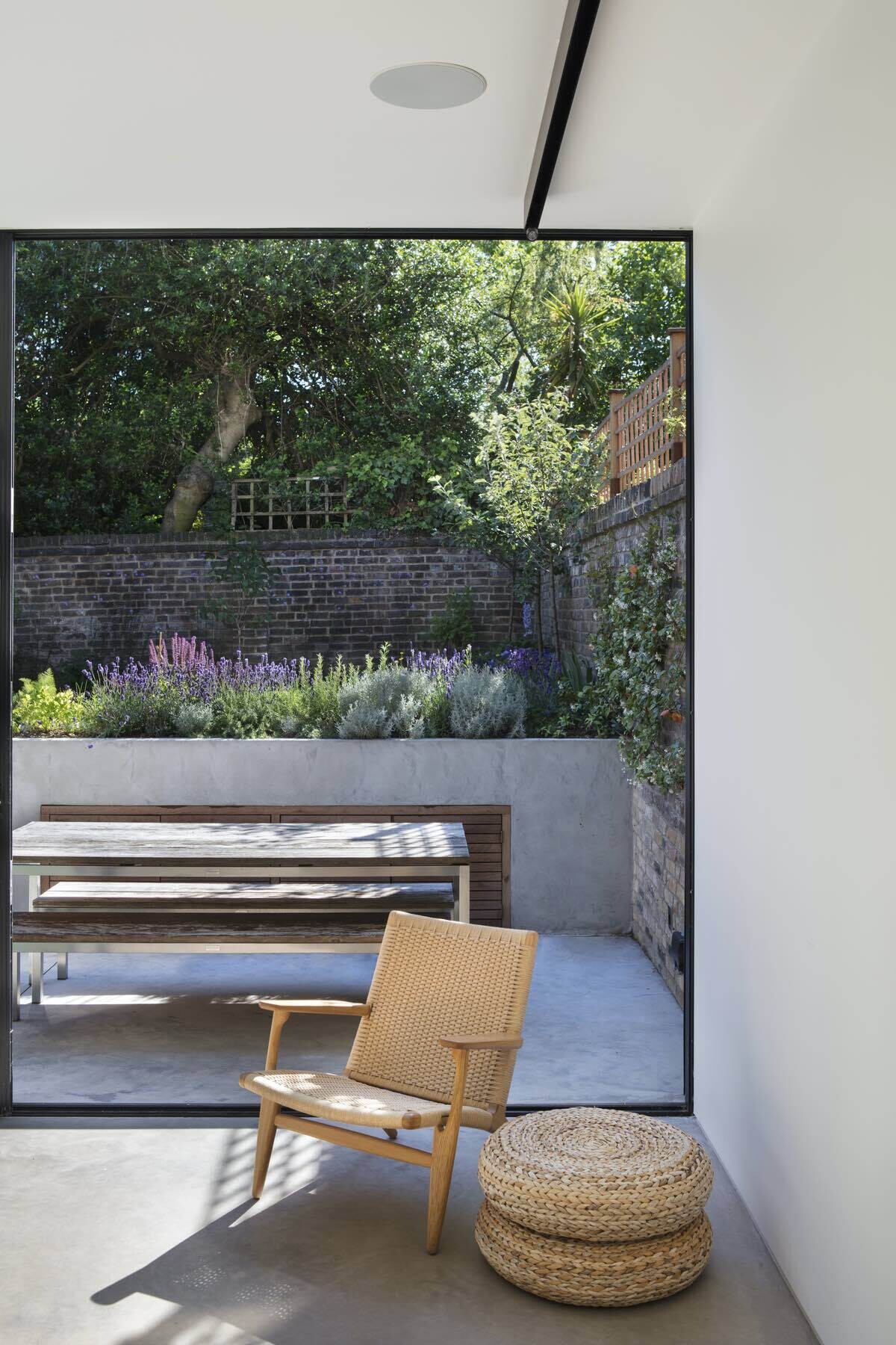 Floor to ceiling sliding doors and a suspended pivoting fireplace complete this light filled London extension with seamless access to a secluded garden.